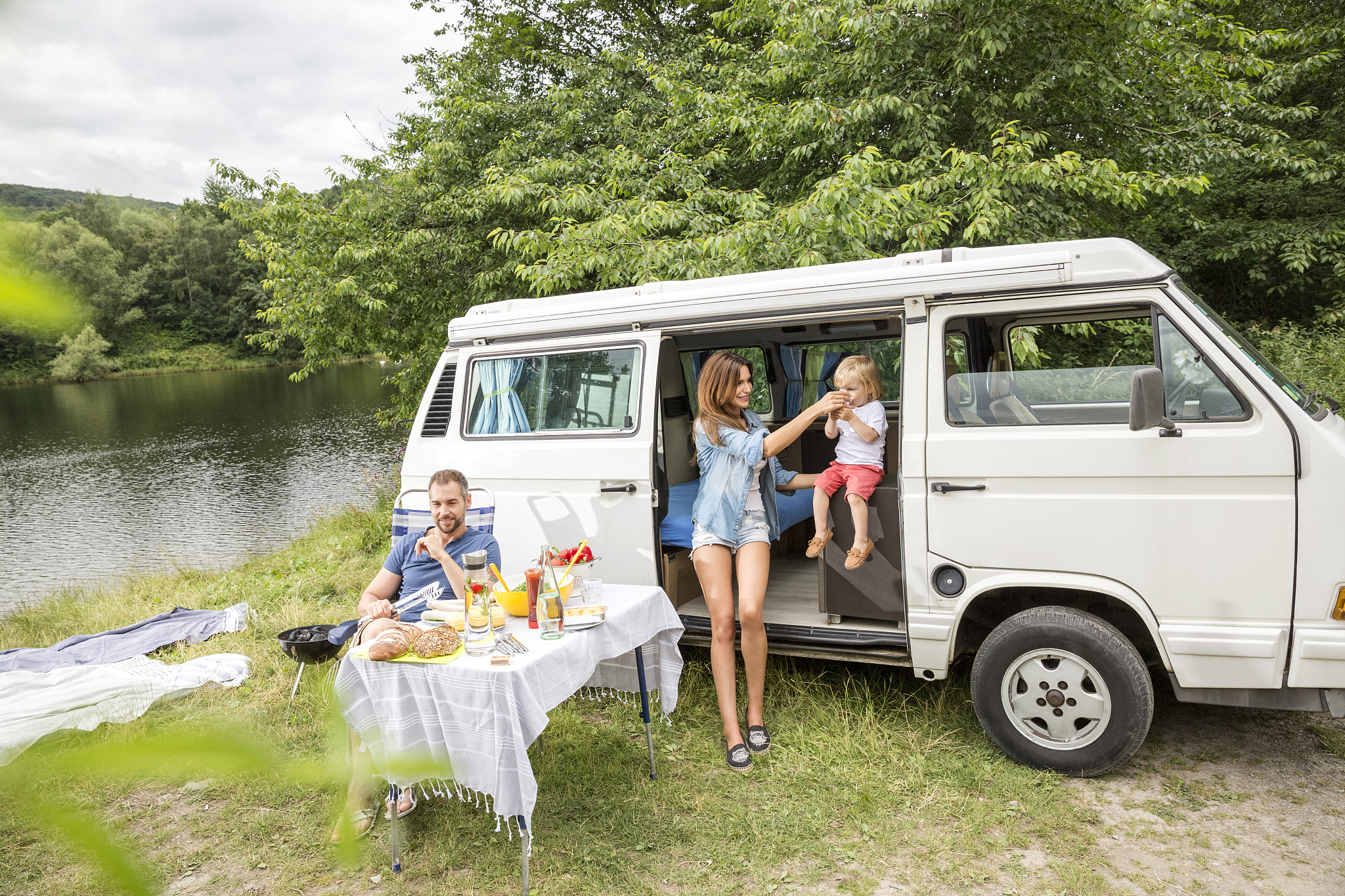 family with van at lakeside