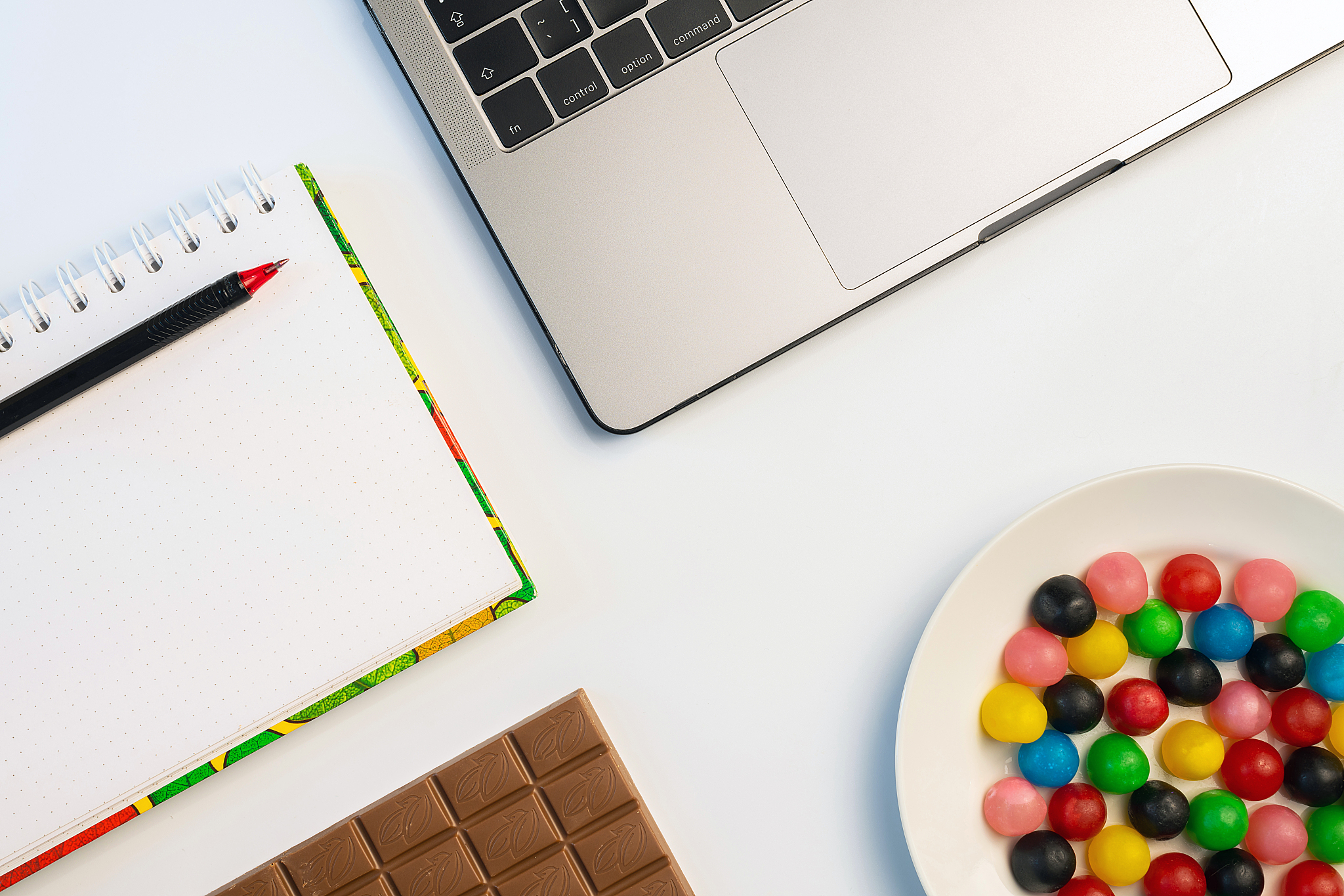 snacking at work, have a bite concept. laptop, candy and workboo
