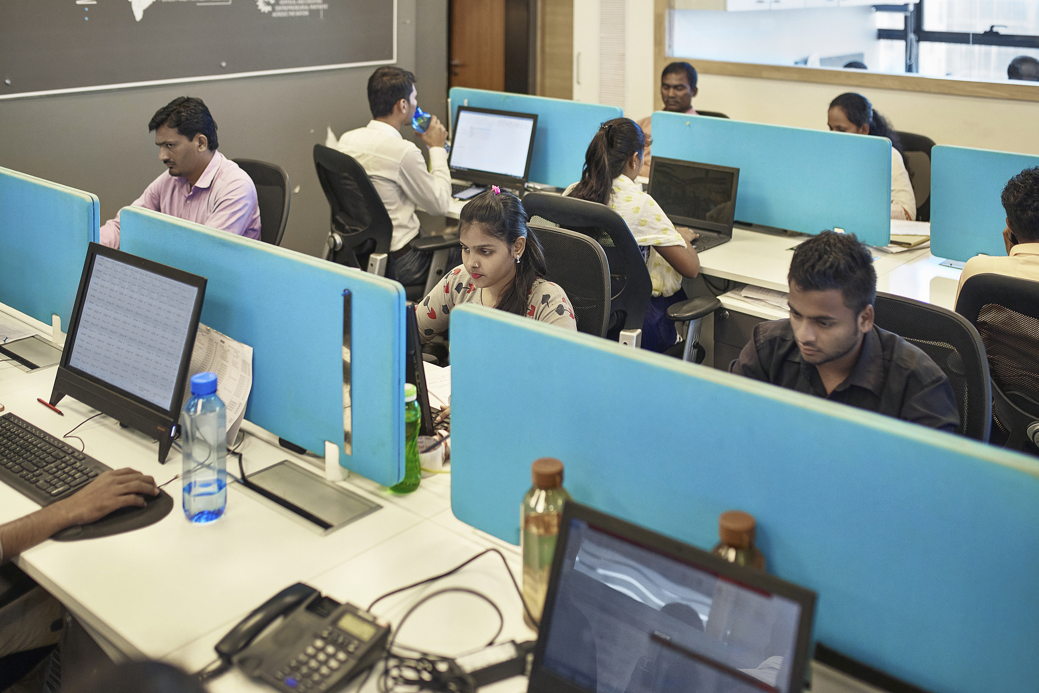 focused indian office workers sitting at computers