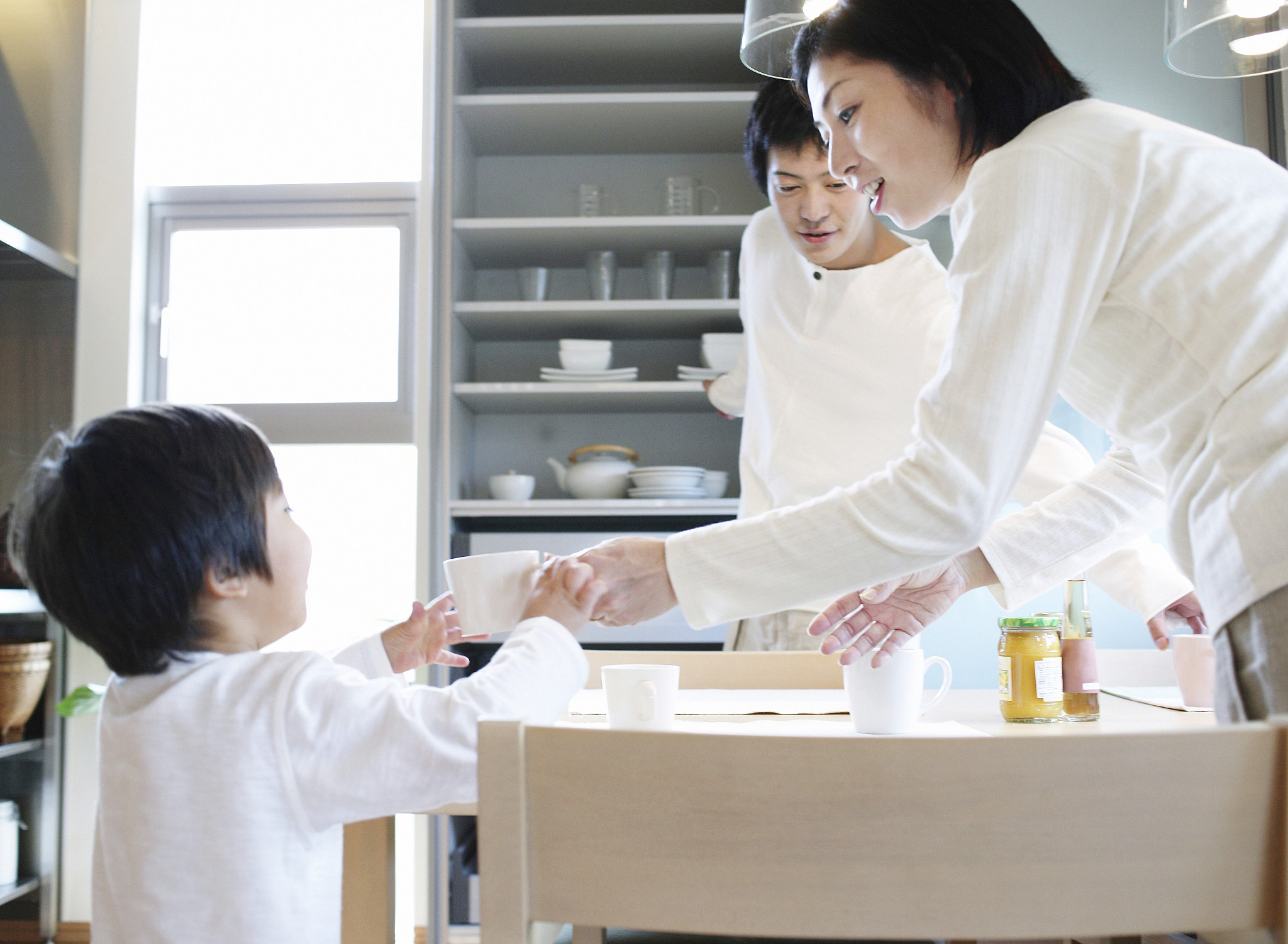 mother giving young boy teacup