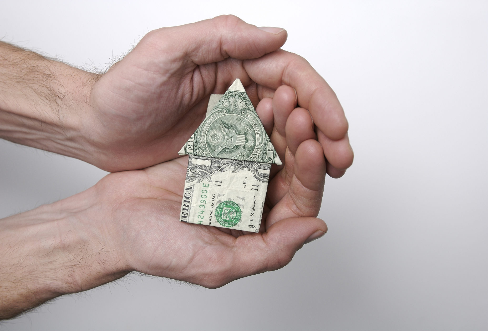 hands holding the american dream origami dollar home