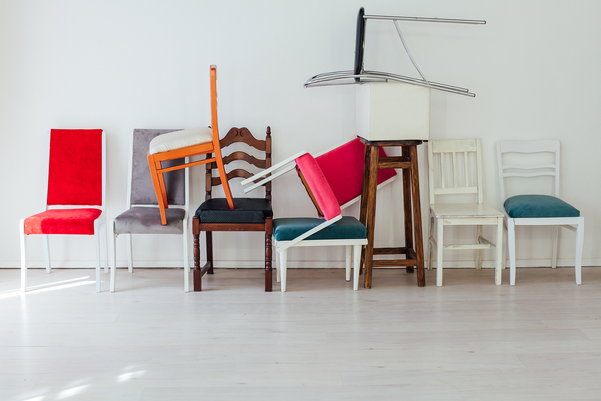 many multicolored chairs in the mess of the white room