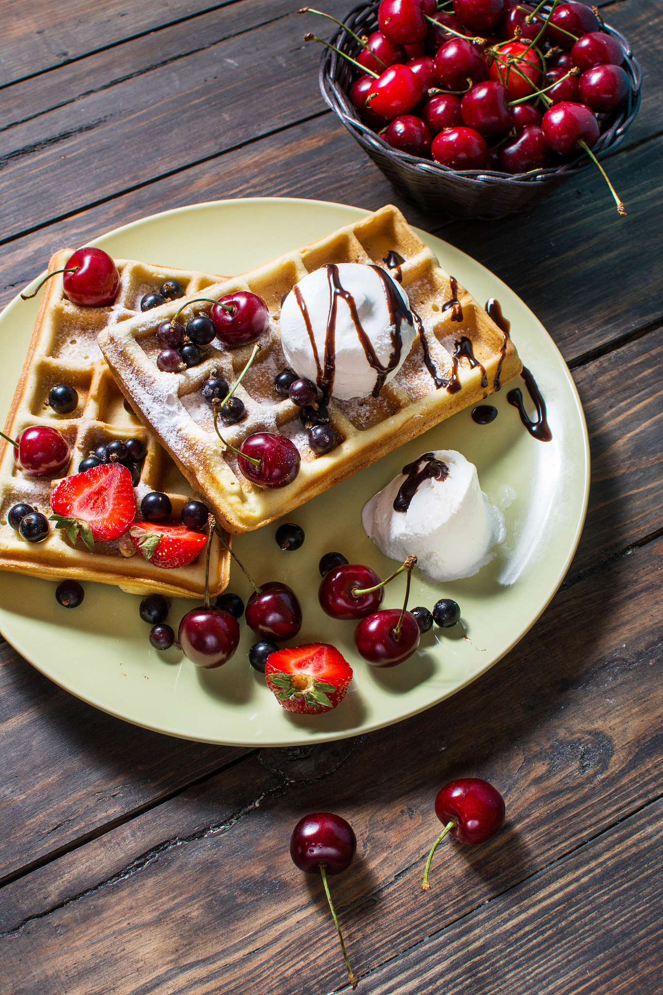 plate of belgian waffles with ice cream, chocolate sauce and fre