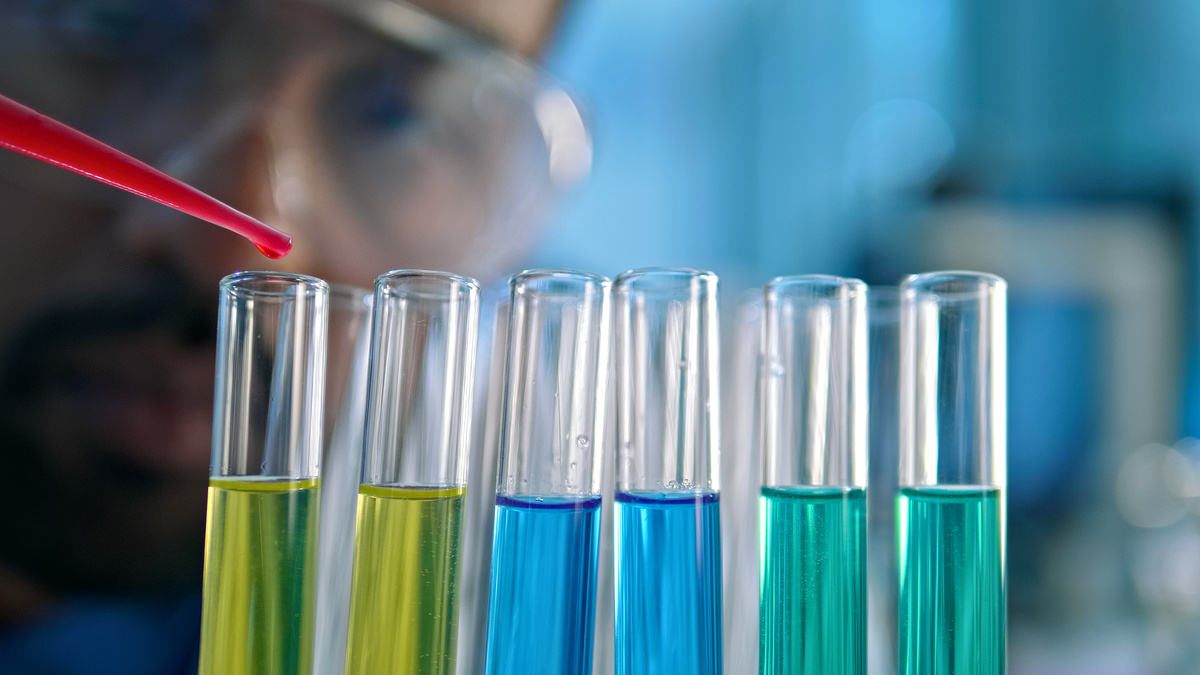 科学家在实验室使用移液管将彩色液体转移到试管中