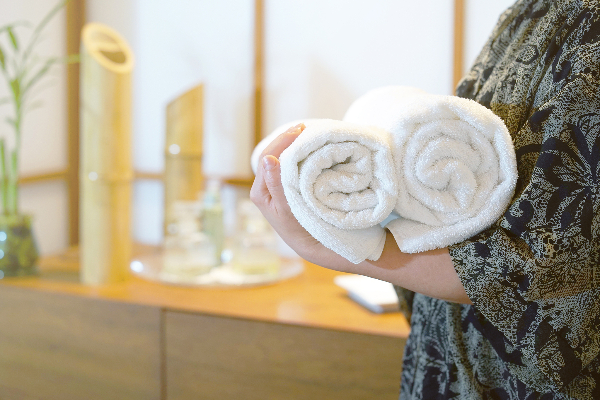 the woman is holding a rolled towel.
