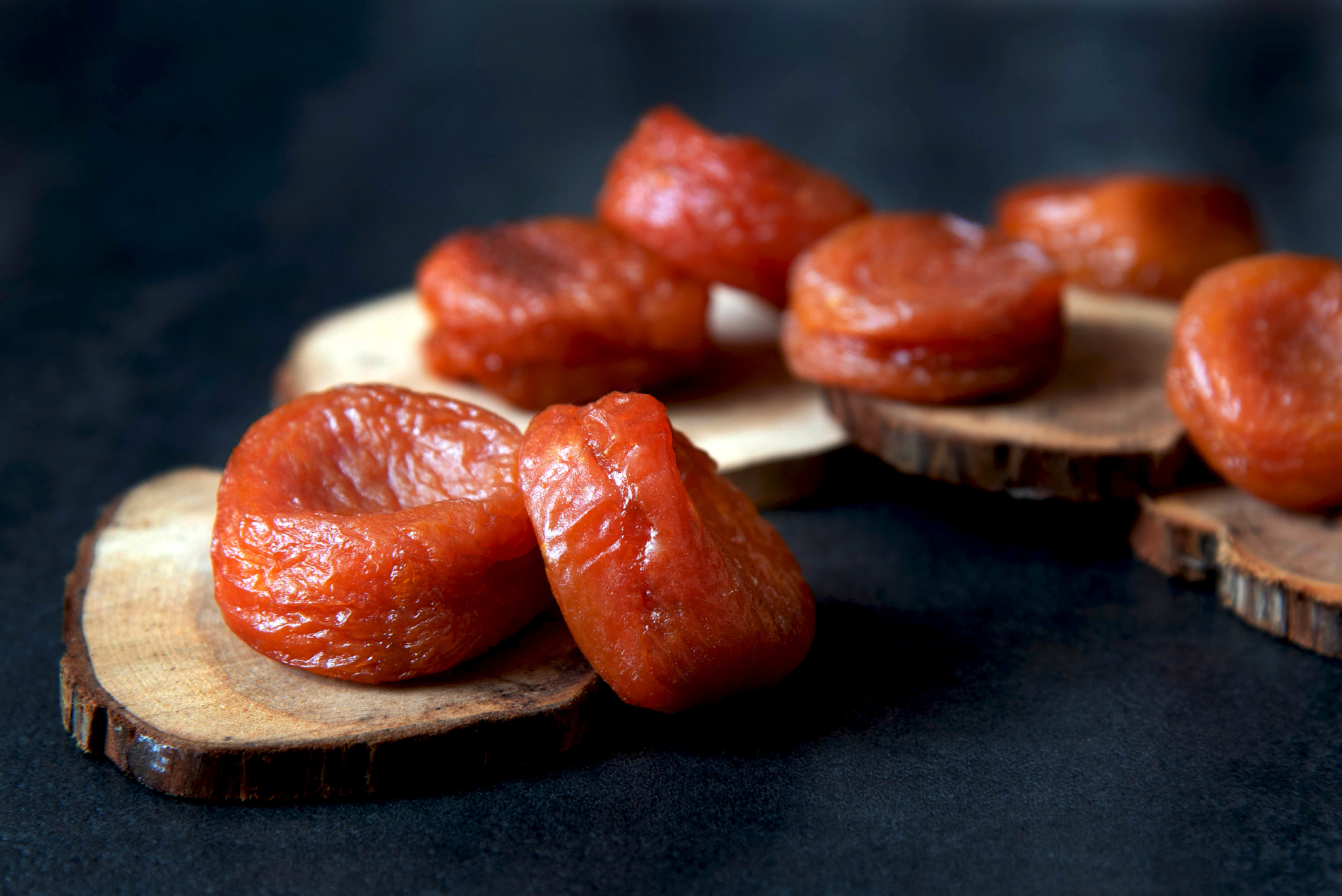 dried apricots on a dark wood background. healthy dessert