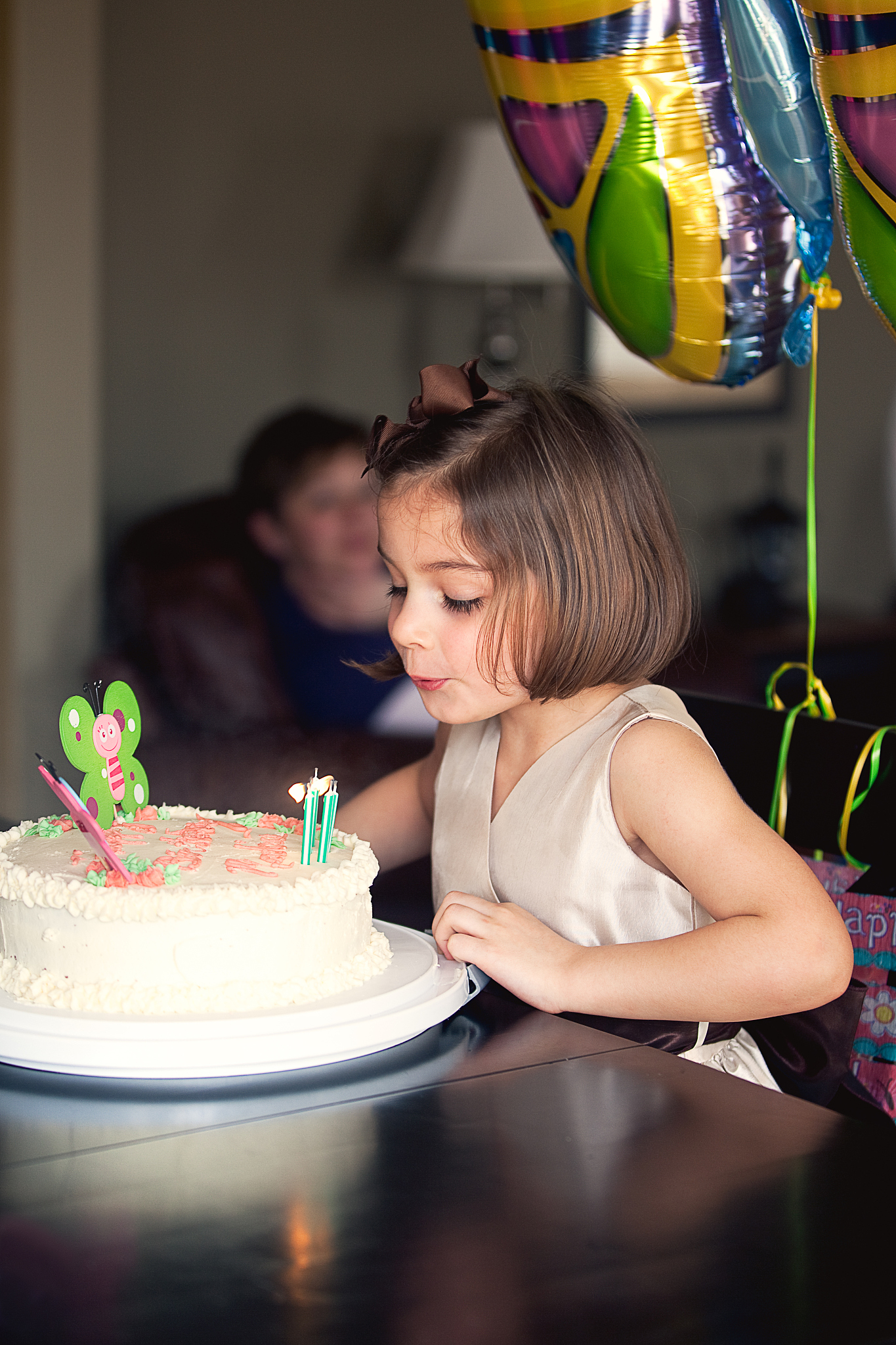 little girl blowing out birthday candles on cake