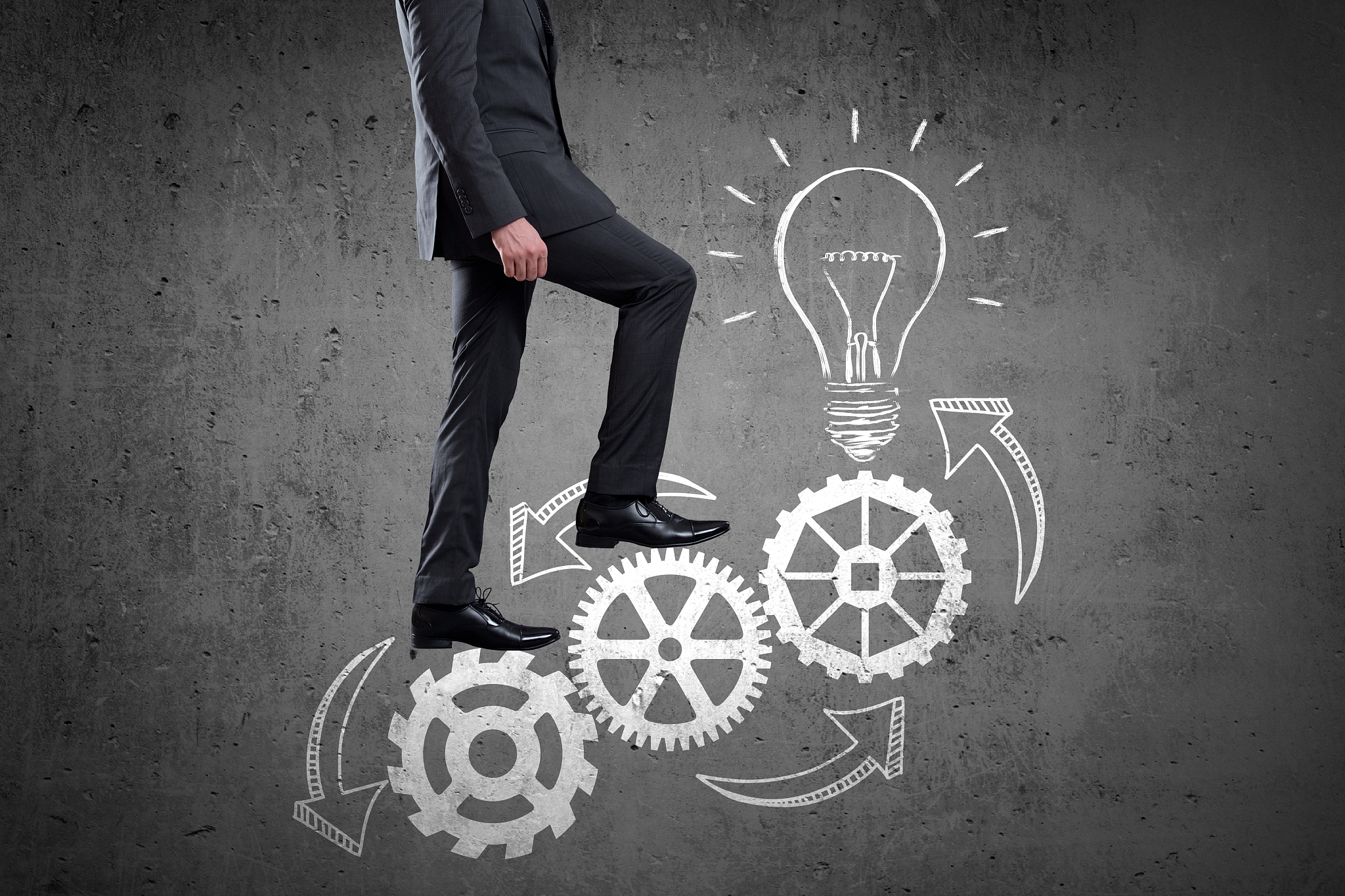 businessman walking up set of gears