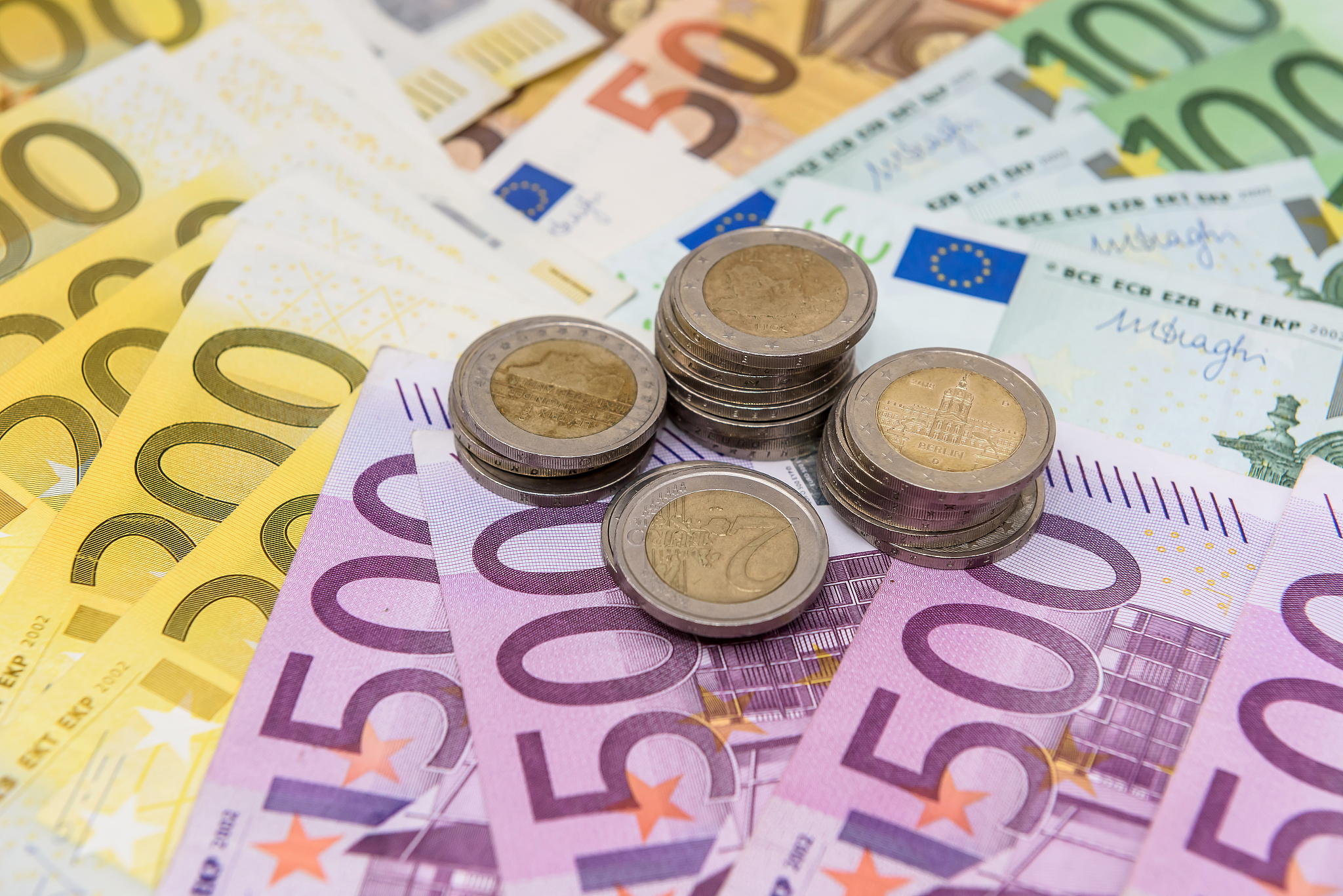 euro cent coins on colorful banknotes close up
