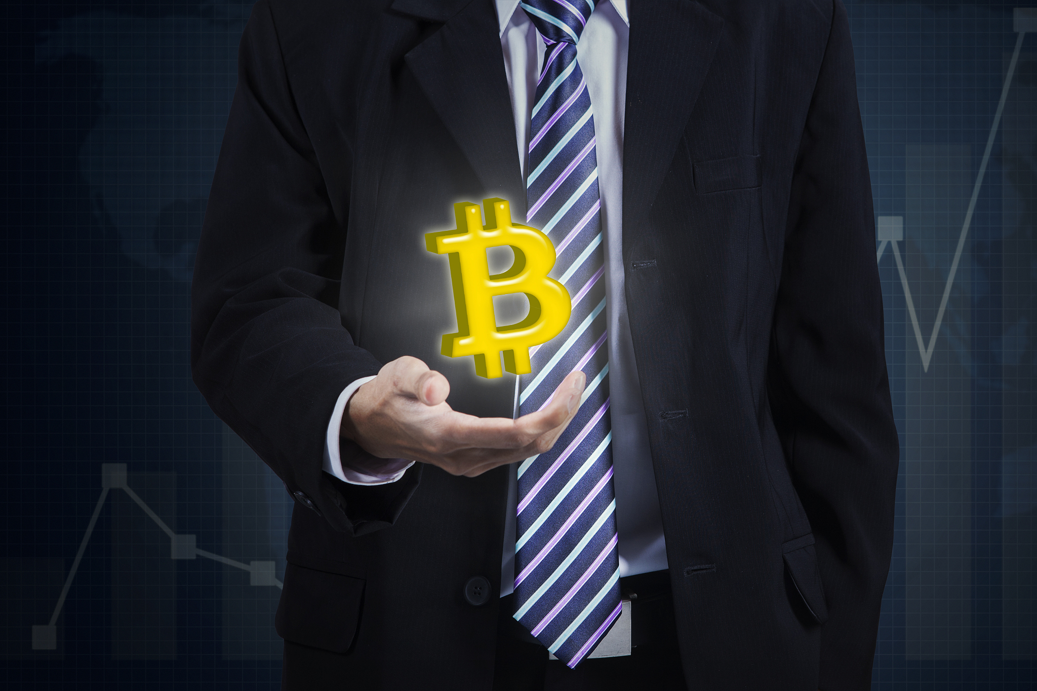 anonymous businessman holding bitcoin symbol
