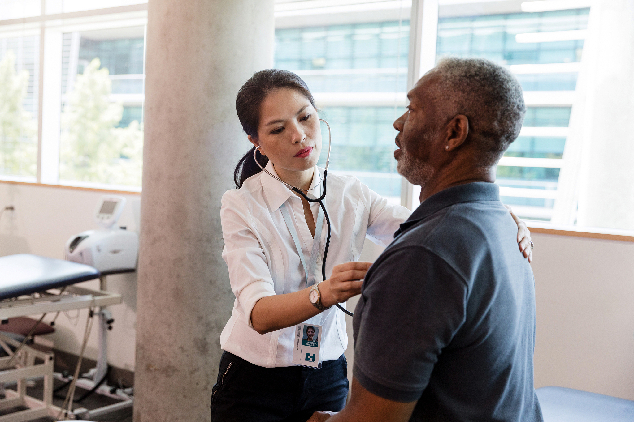 nurse checks heart rate of mature man before physical therapy