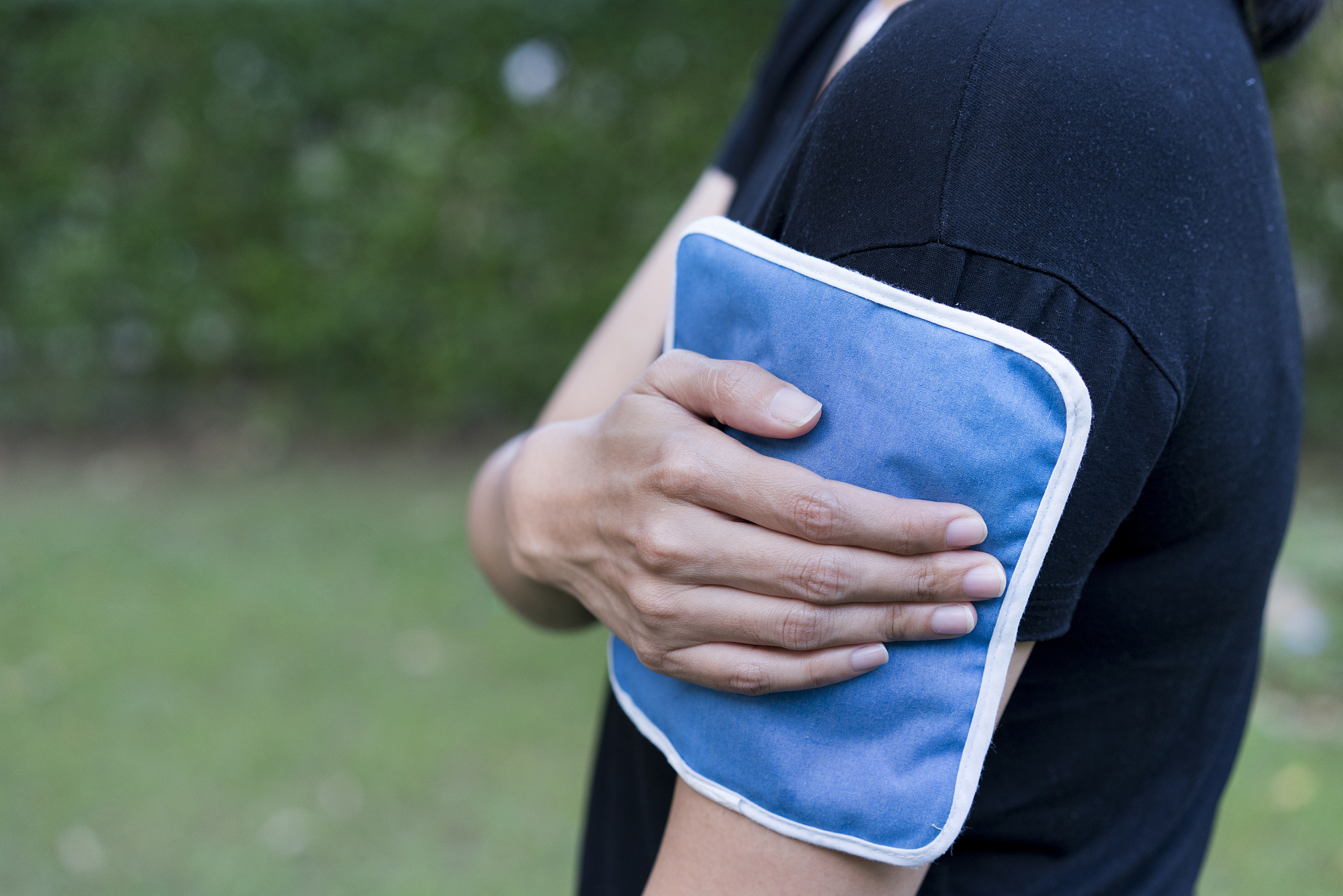 woman putting an ice pack on her arm pain