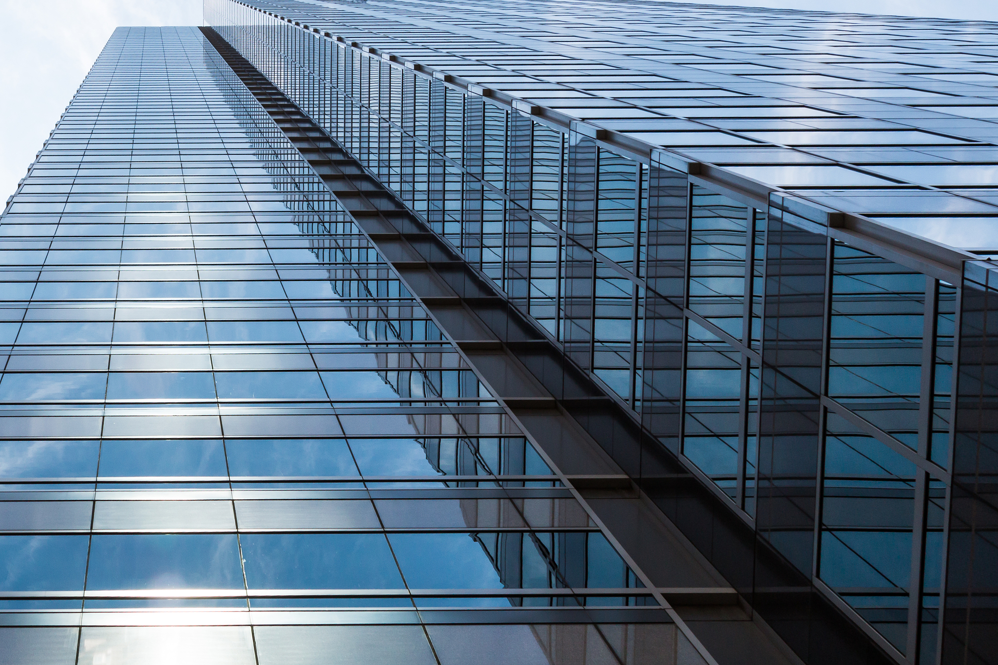 view looking up from bottom of glass skyscraper