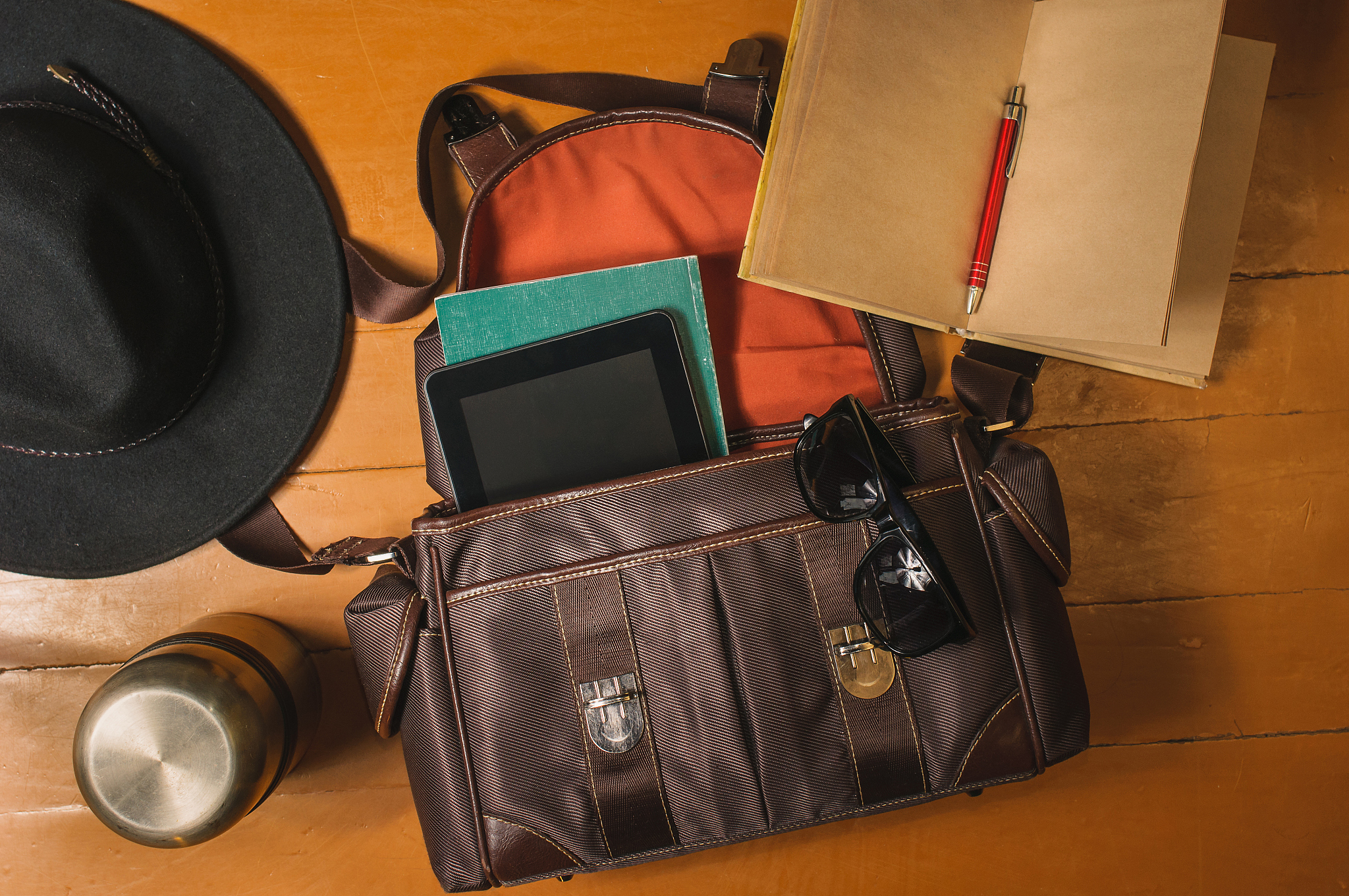 travel accessories on wood: bag, vintage diary, sunglasses and h