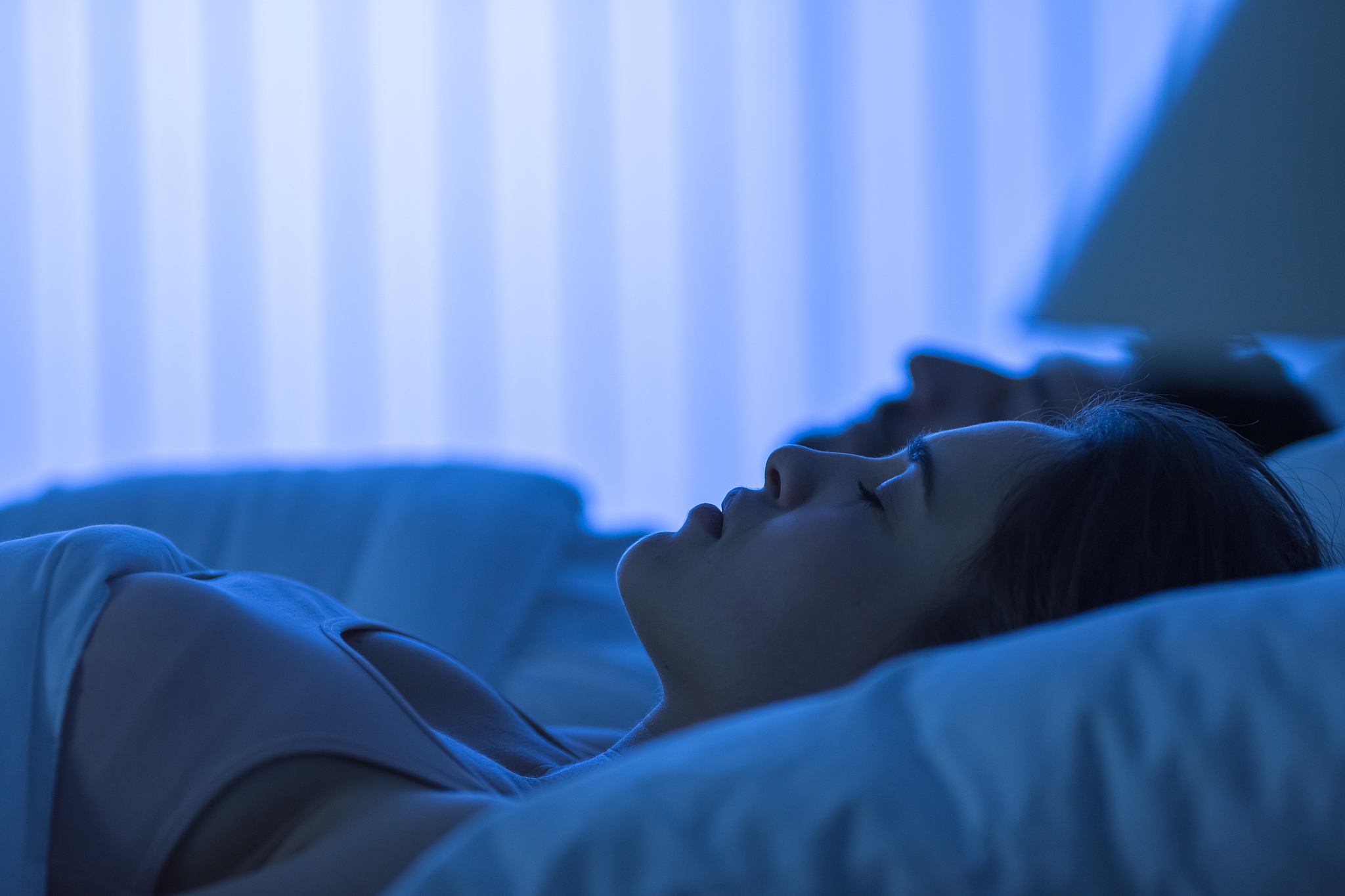 the attractive woman sleeping near the man in the bed. night tim