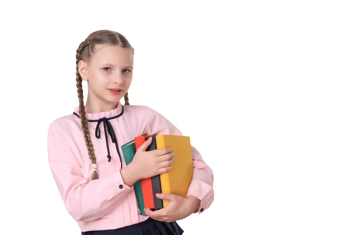梳着辫子的小学女生,手持书籍,在白色背景下被隔离