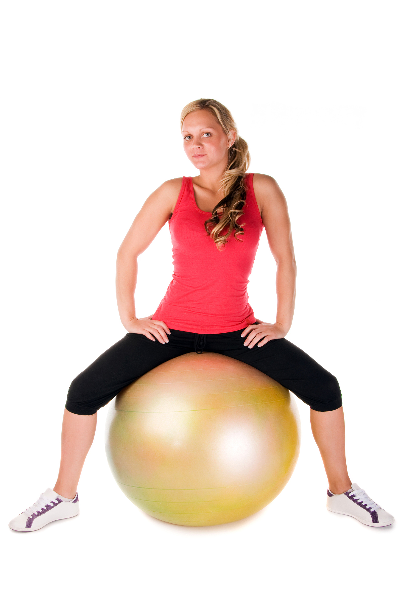 blond woman exercising with a pilates ball