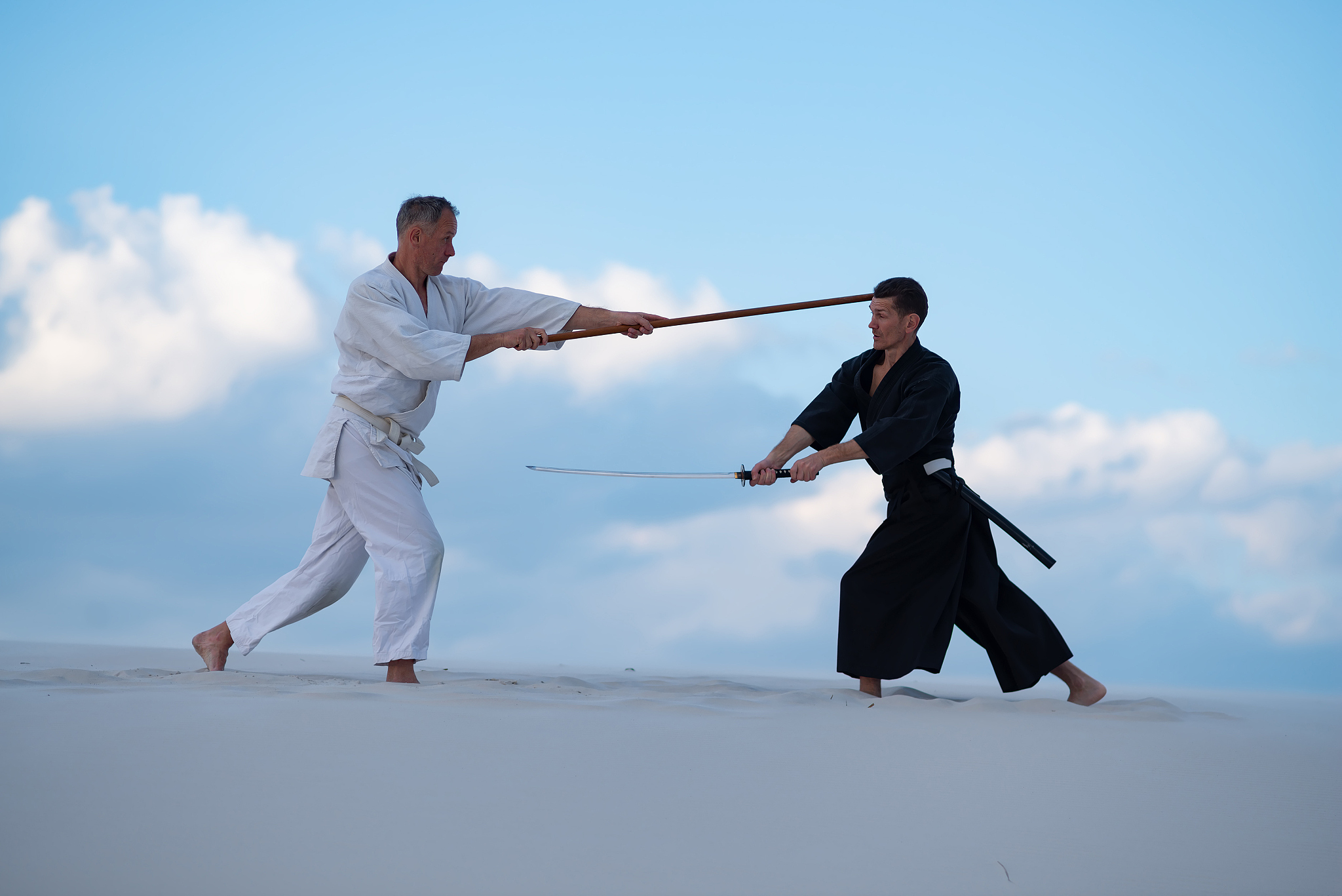 two concentrated men, in japanese clothes, are practicing martia