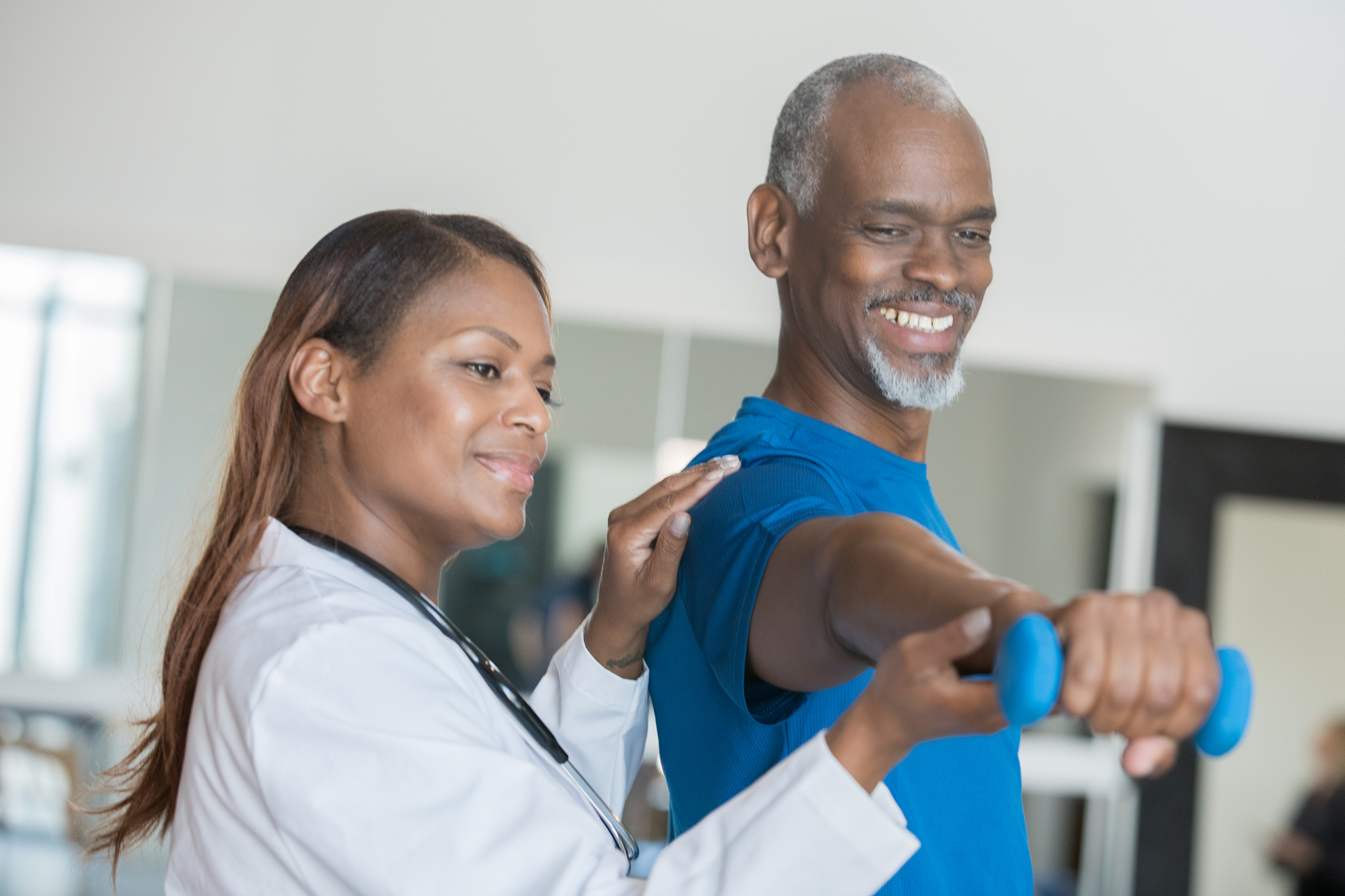 physical therapist assisting senior man at therapy