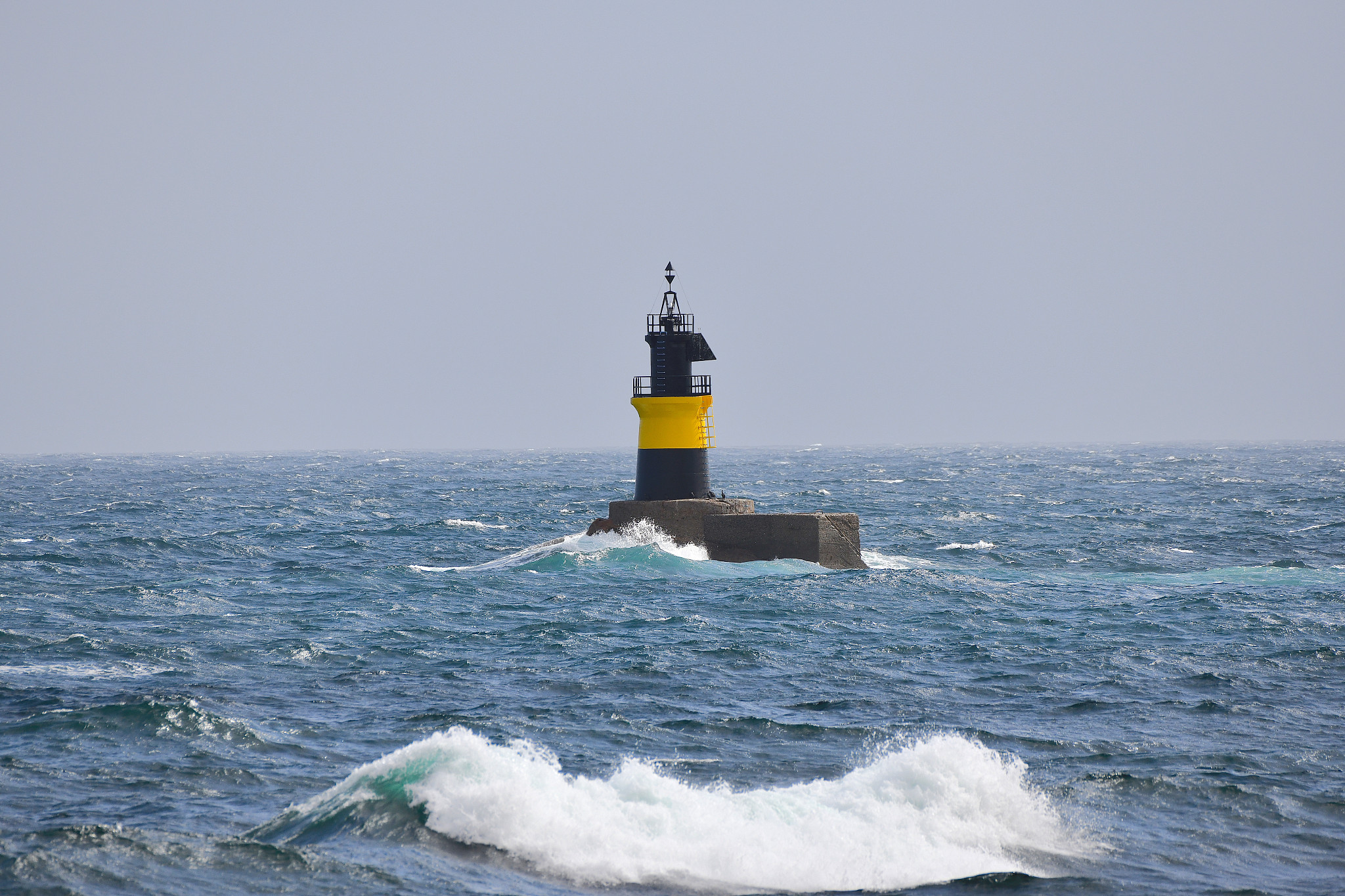 lighthouse on sea against clear sky