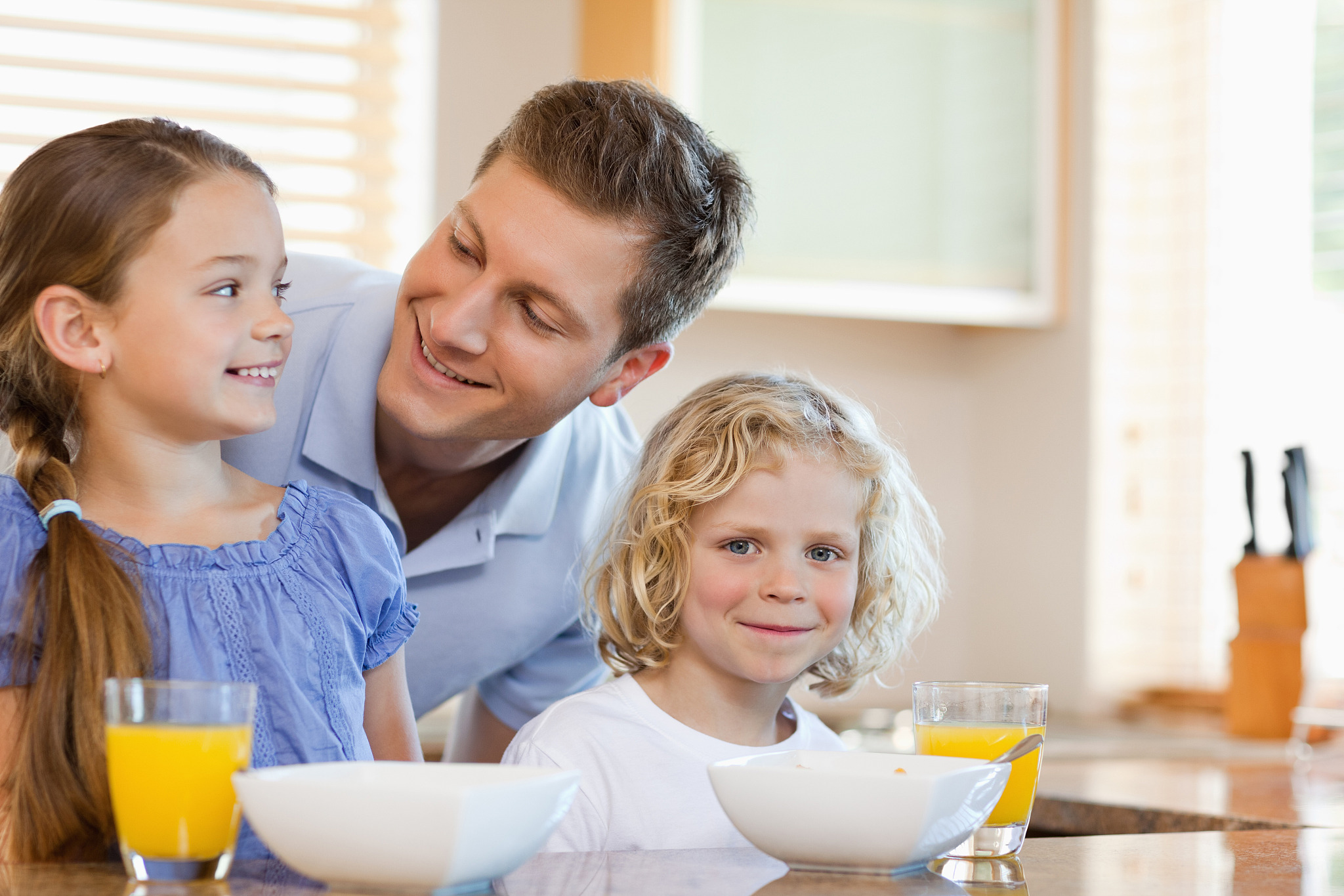 father together with his children behind the kitchen counter