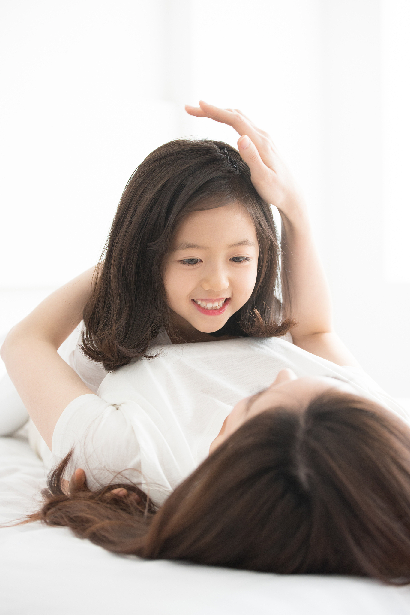 mom and daughter having a good time on a bed