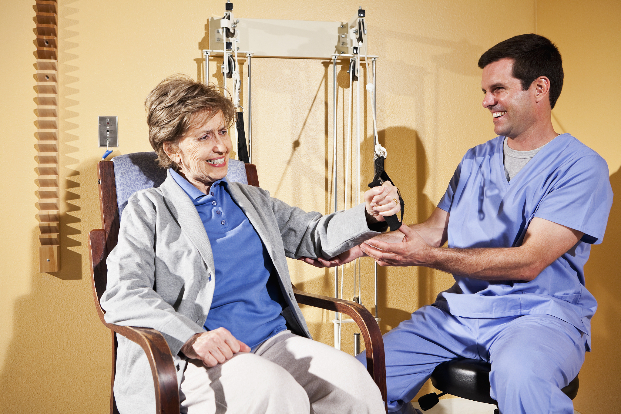 physical therapist working with patient on upper extremity exerc