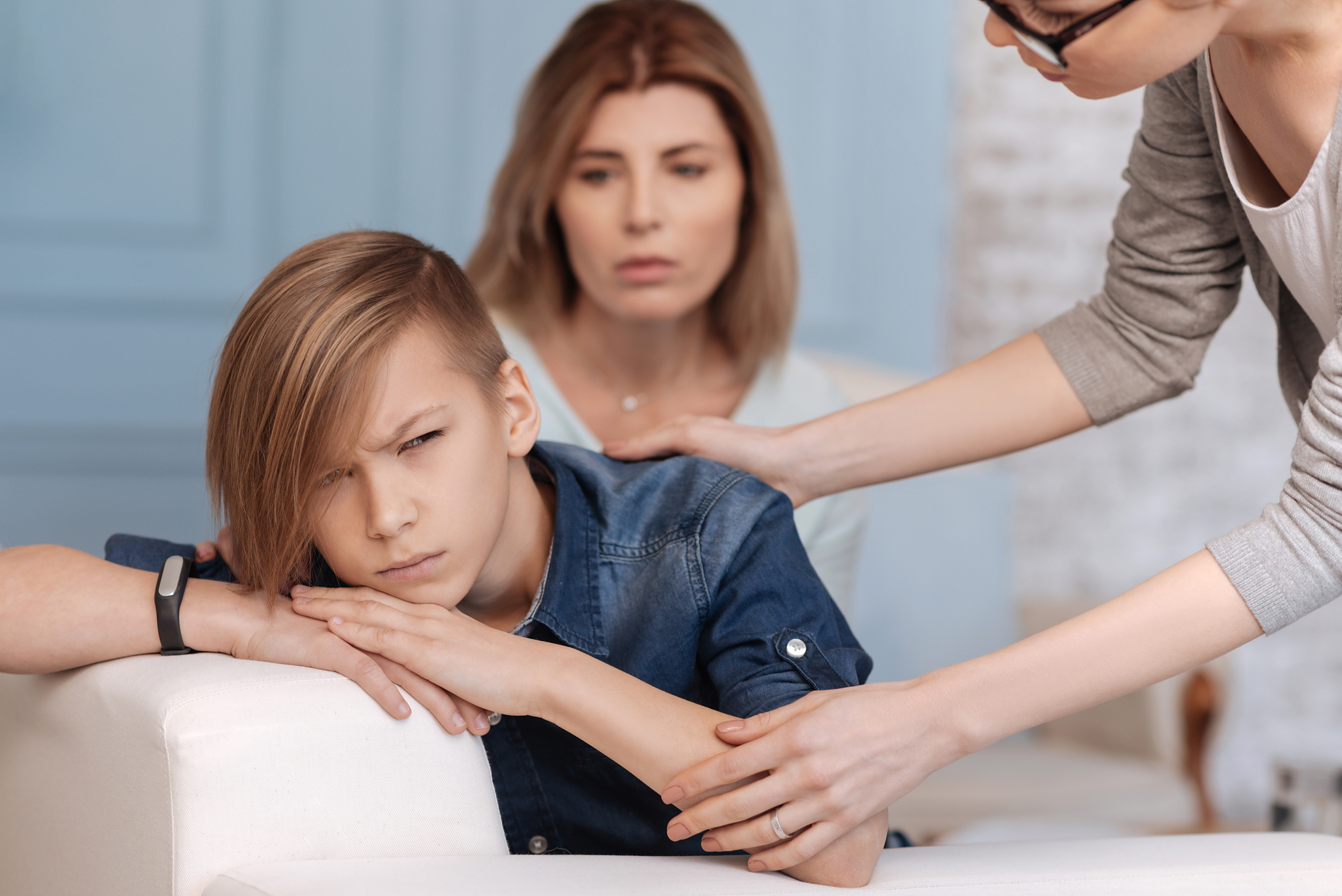 angry teenager wrinkling visiting psychologist with his mother
