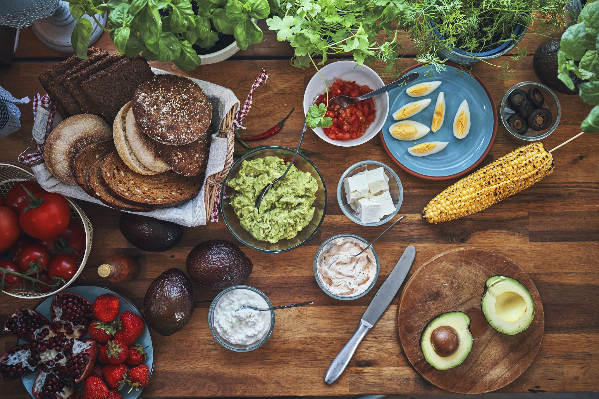 preparing avocado sandwich with brown bread and pomegranate