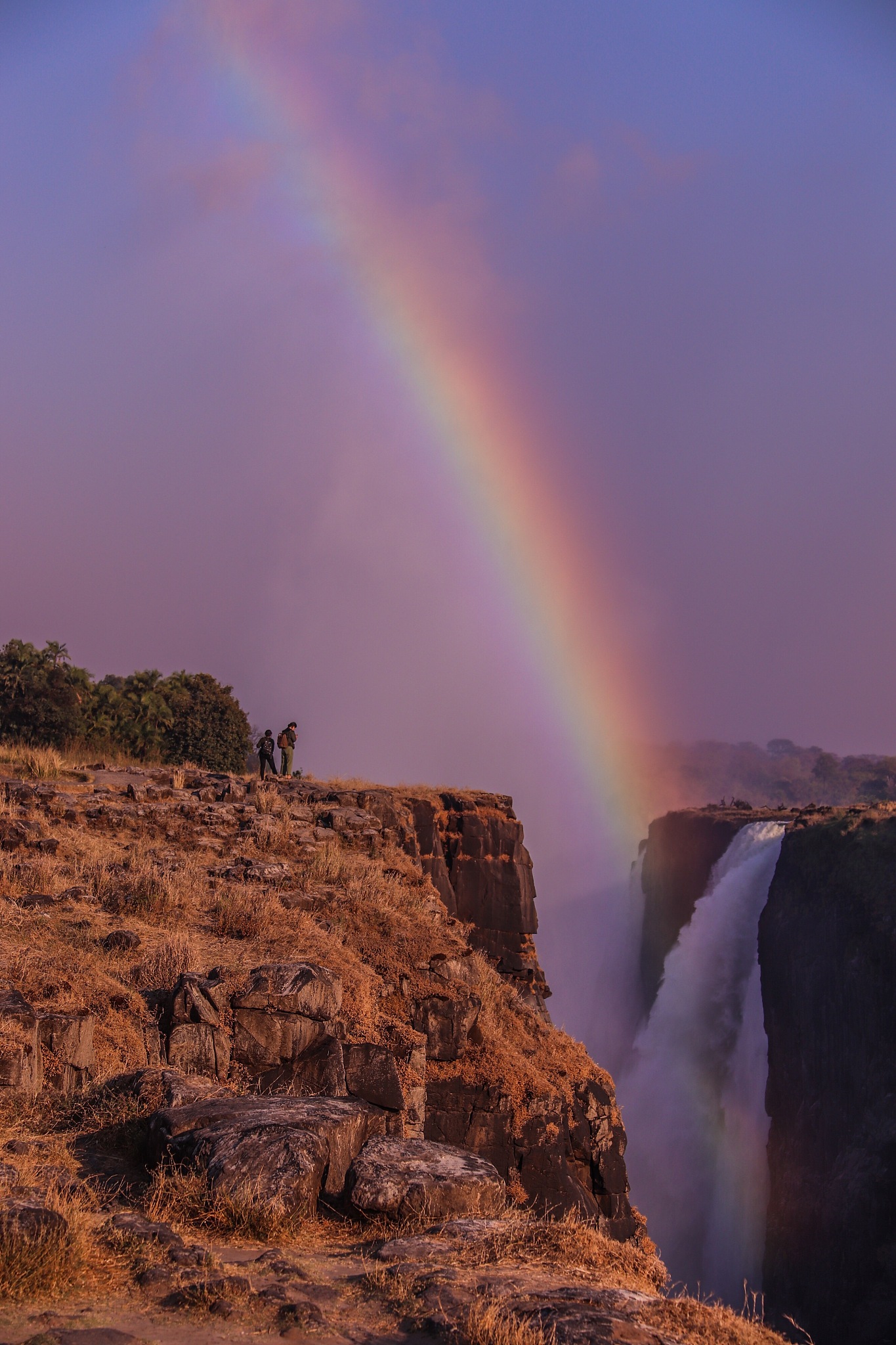 scenic view of rainbow over rocks against sky