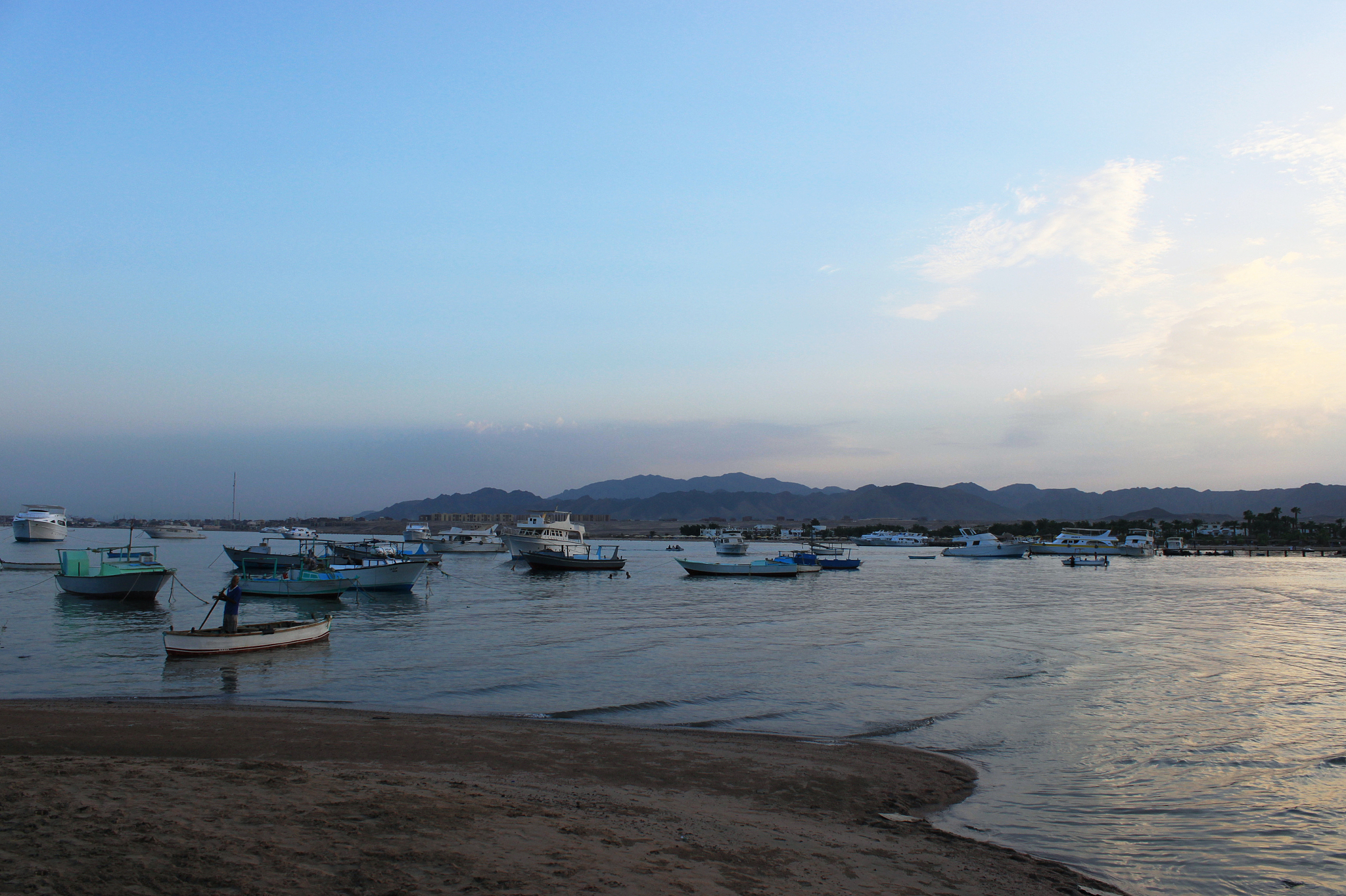 bay and boats on the water. low mountains in the distance. resor