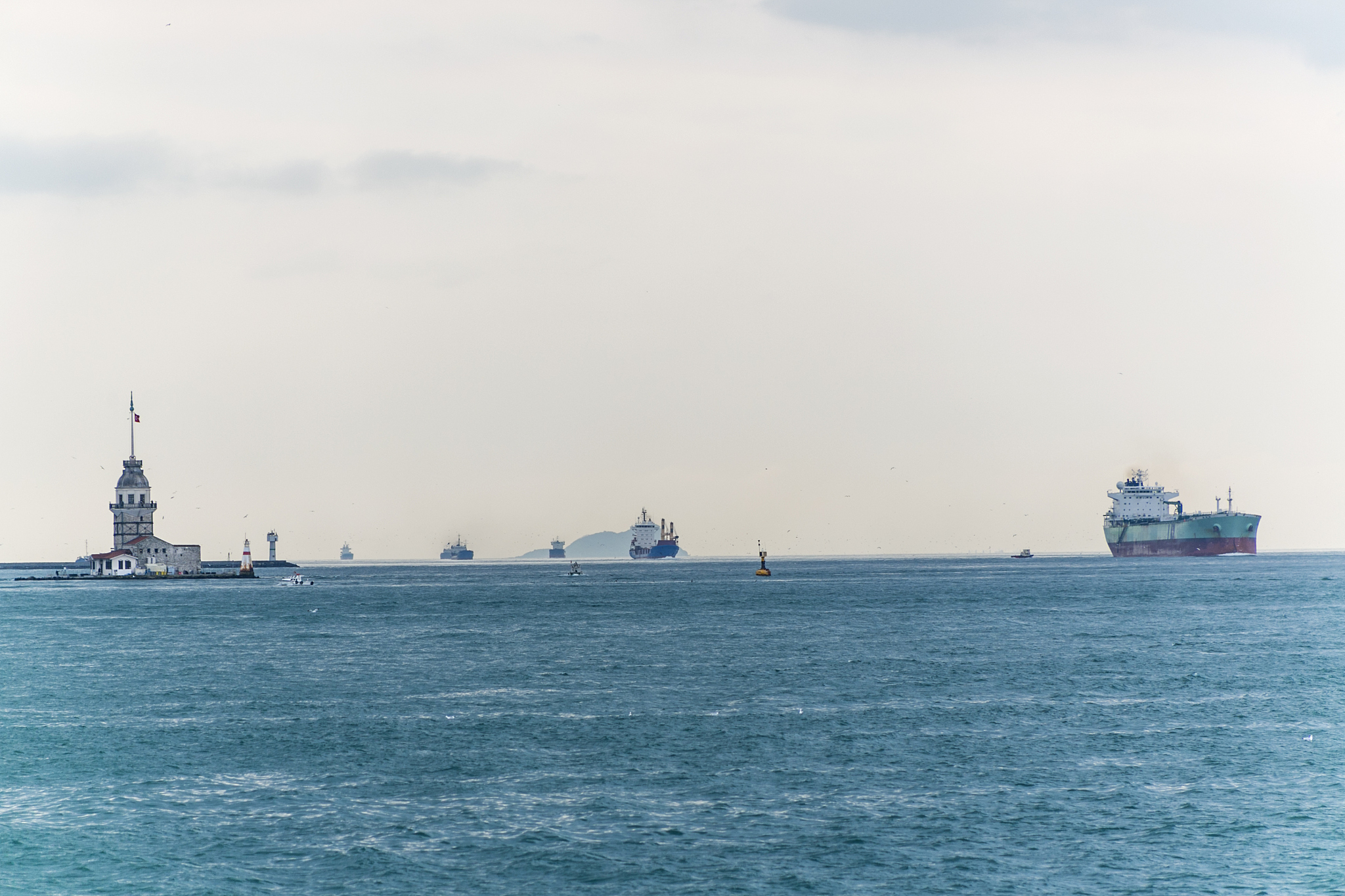 industrial ships are passing by historical maiden tower at middl