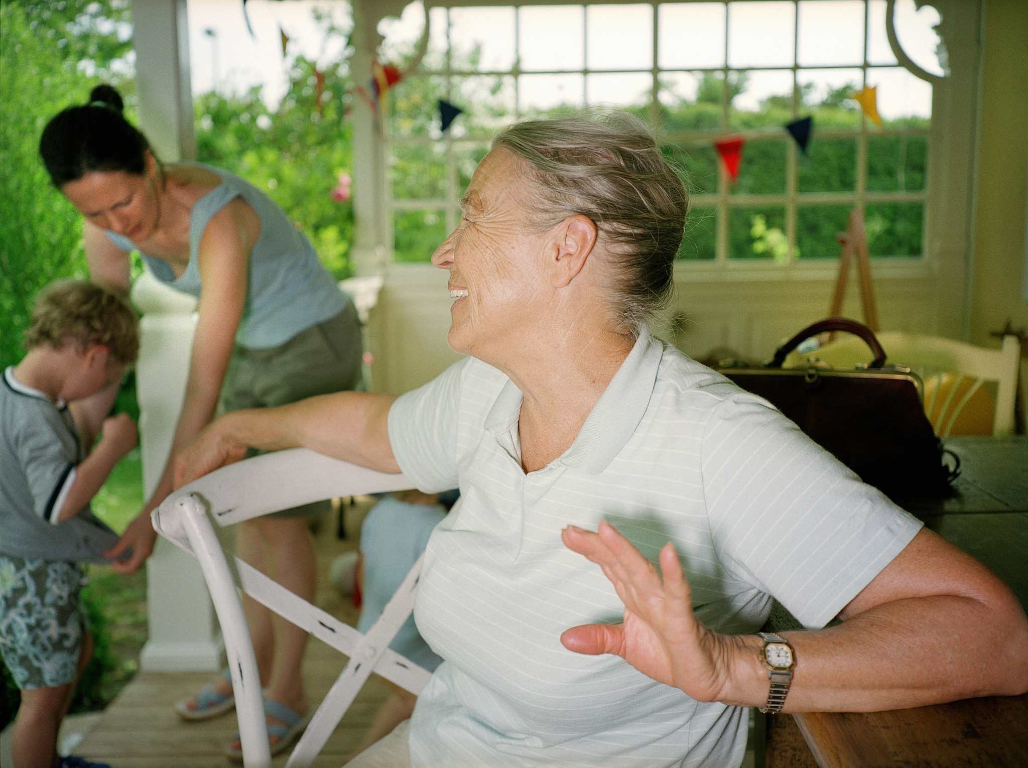senior woman looking over shoulder at mother and son ((3-5)