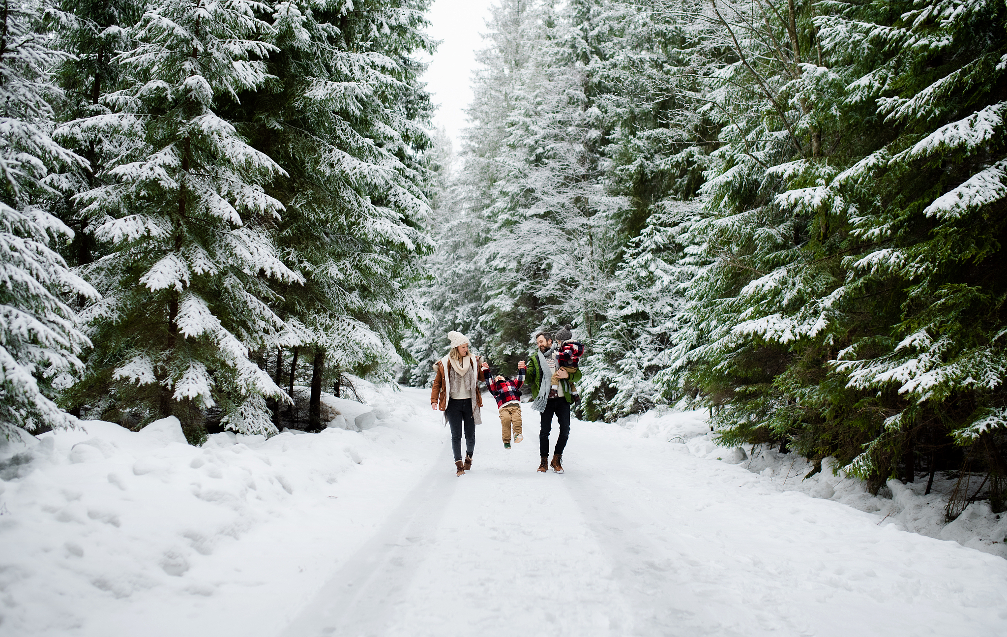 portrait of family with two small children enjoying snow in wint