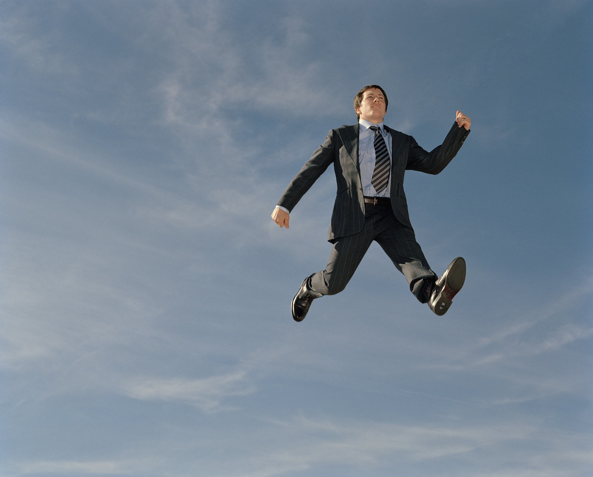young businessman walking in mid air, low angle view