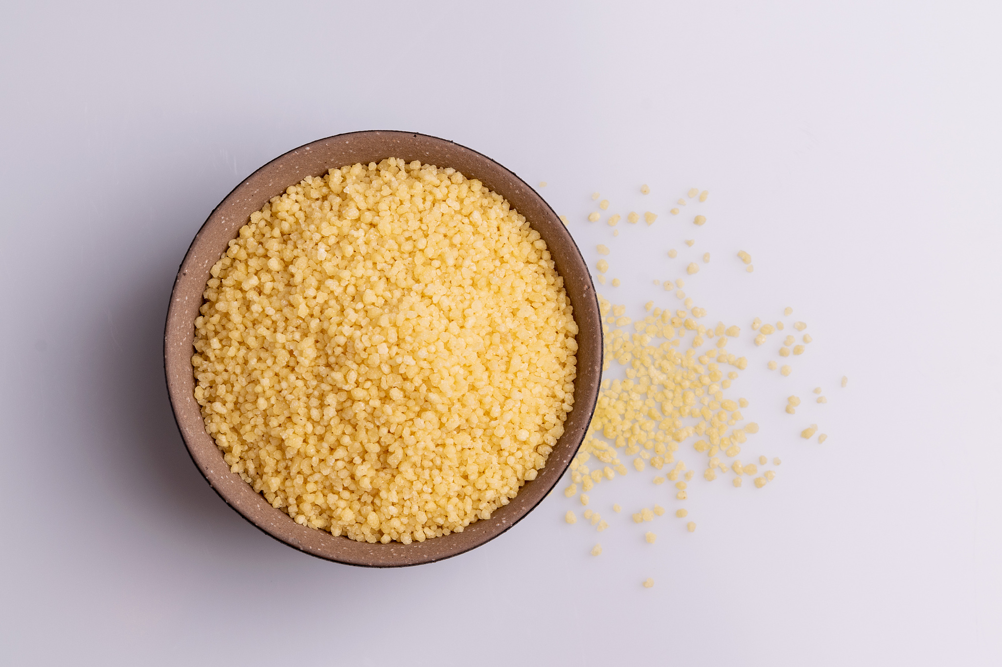 dry couscous isolated on white background, soft light, copy spac