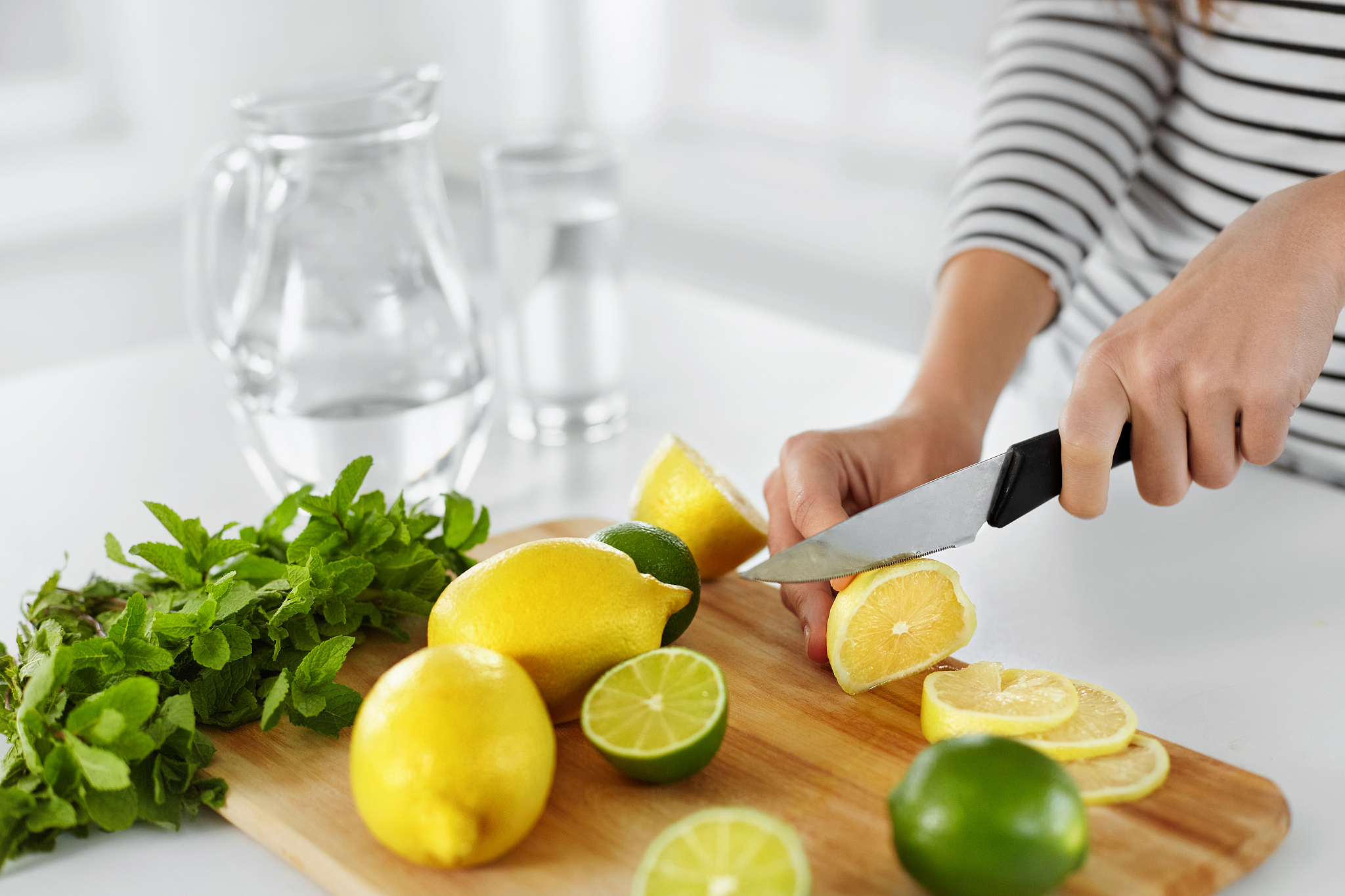 healthy food and eating. closeup of woman kitchen cutting lemons