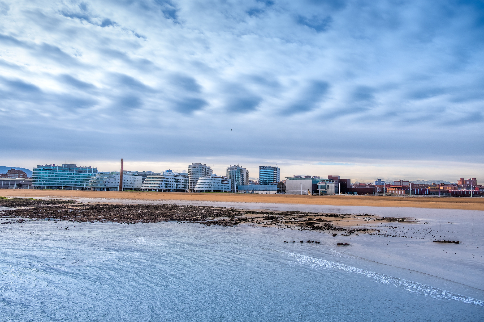 view of poniente beach and cityscape, gijón, asturias, spain.