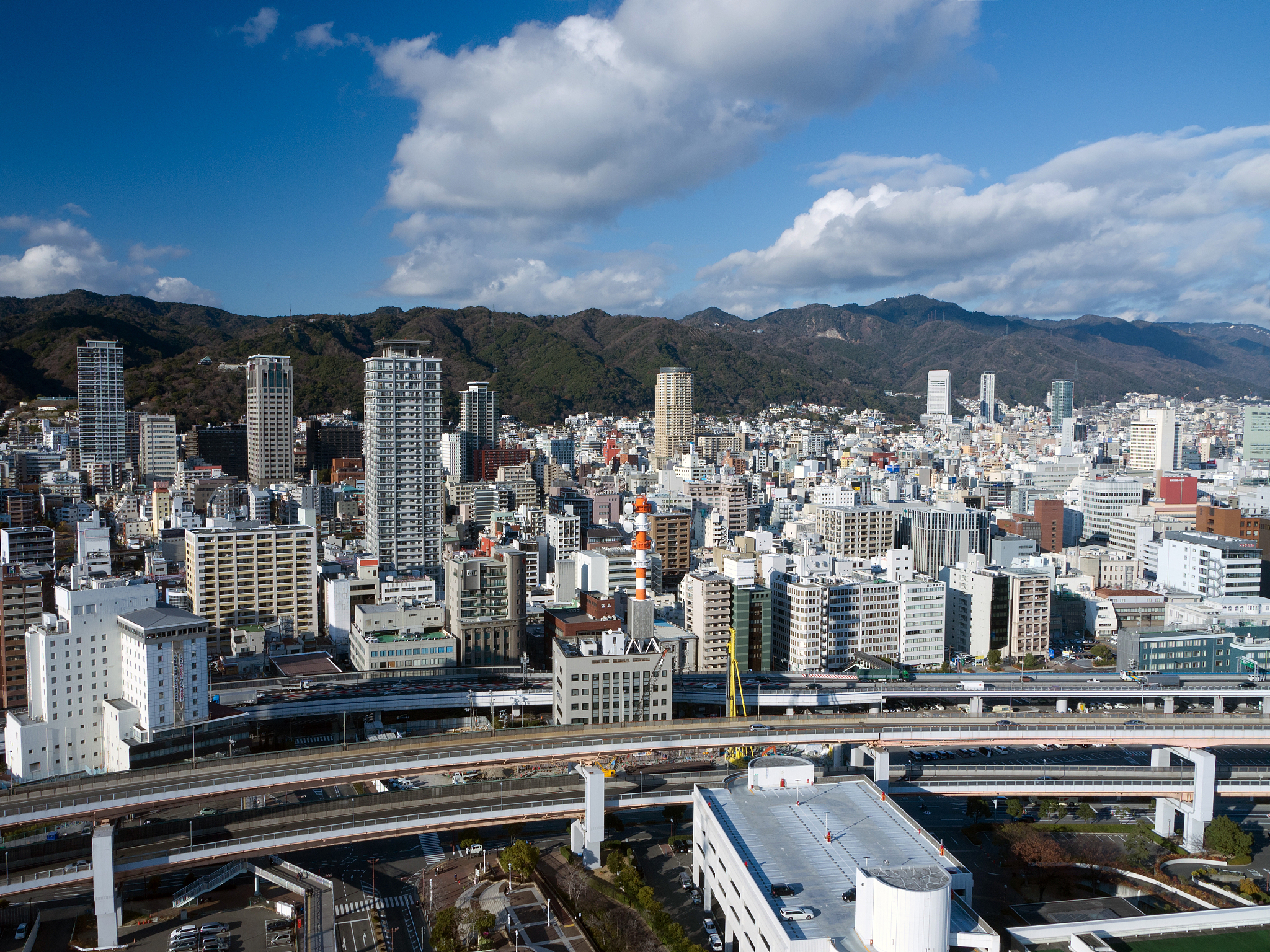 kobe downtown cityscape with elevated road and mountains in back