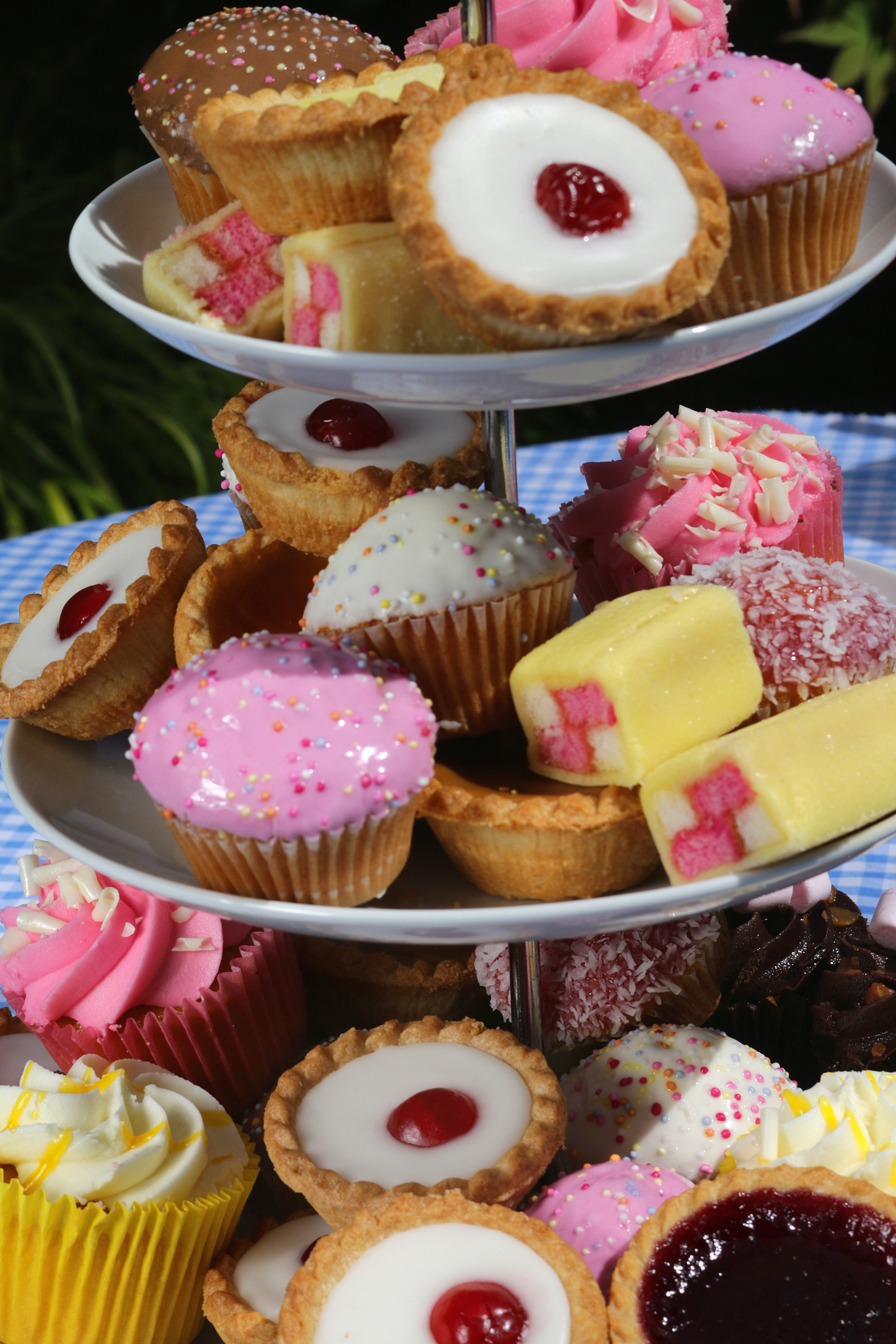image of afternoon tea buffet picnic of cupcakes cakes on white 
