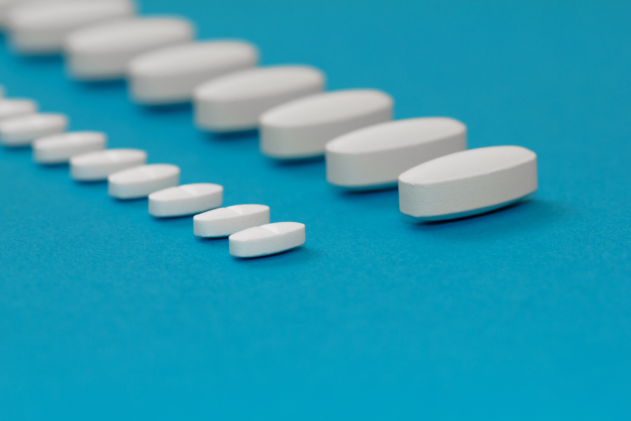 white tablets on a blue background close-up. macro pills. medica