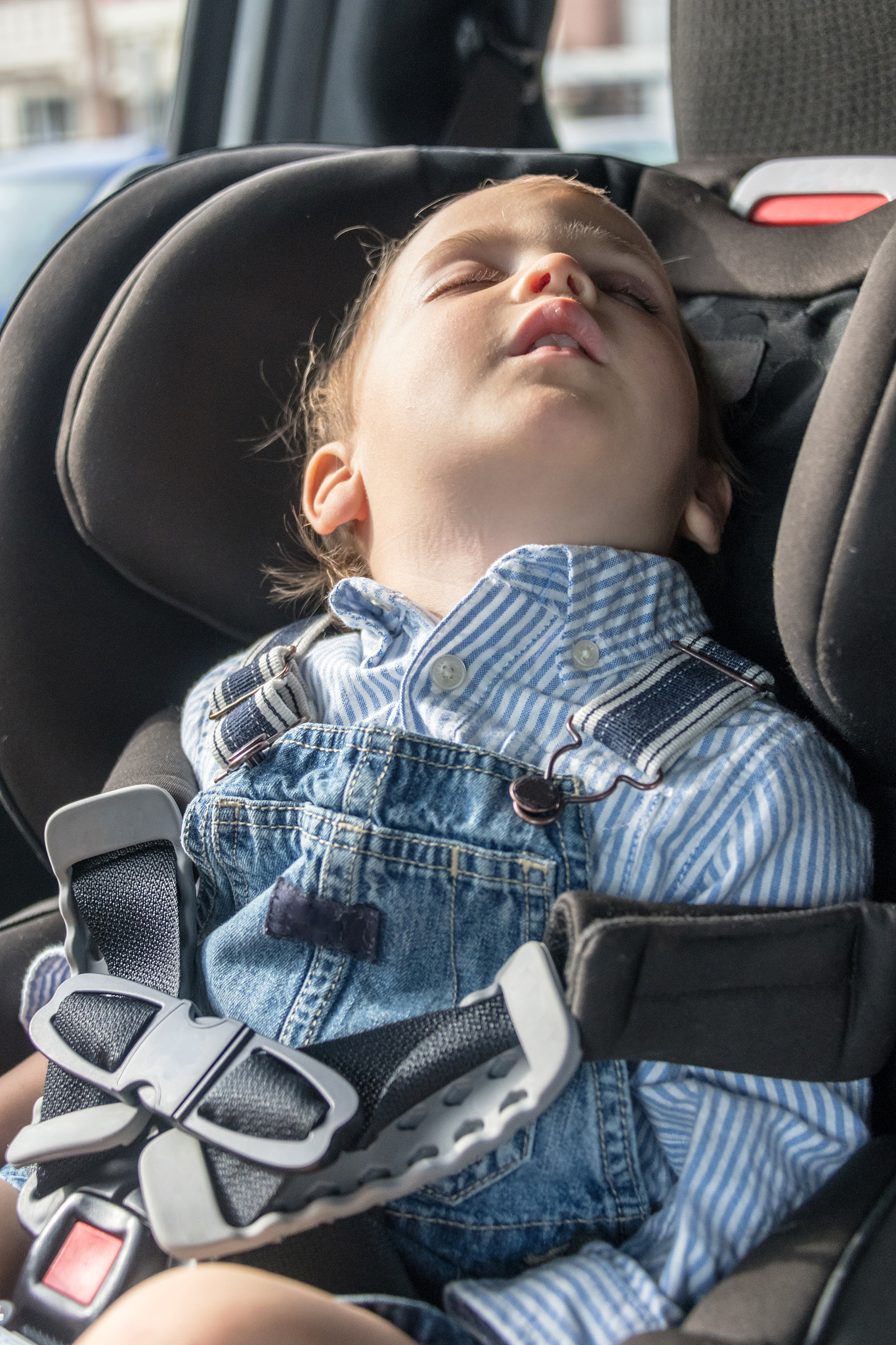 toddler sitting in his car seat sleeping