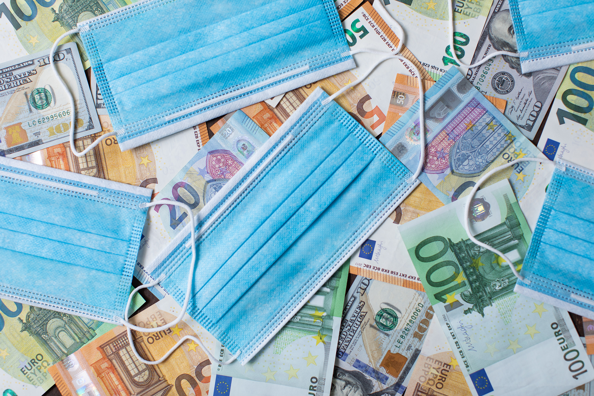 money, dollars and euro banknotes and a protective medical mask.