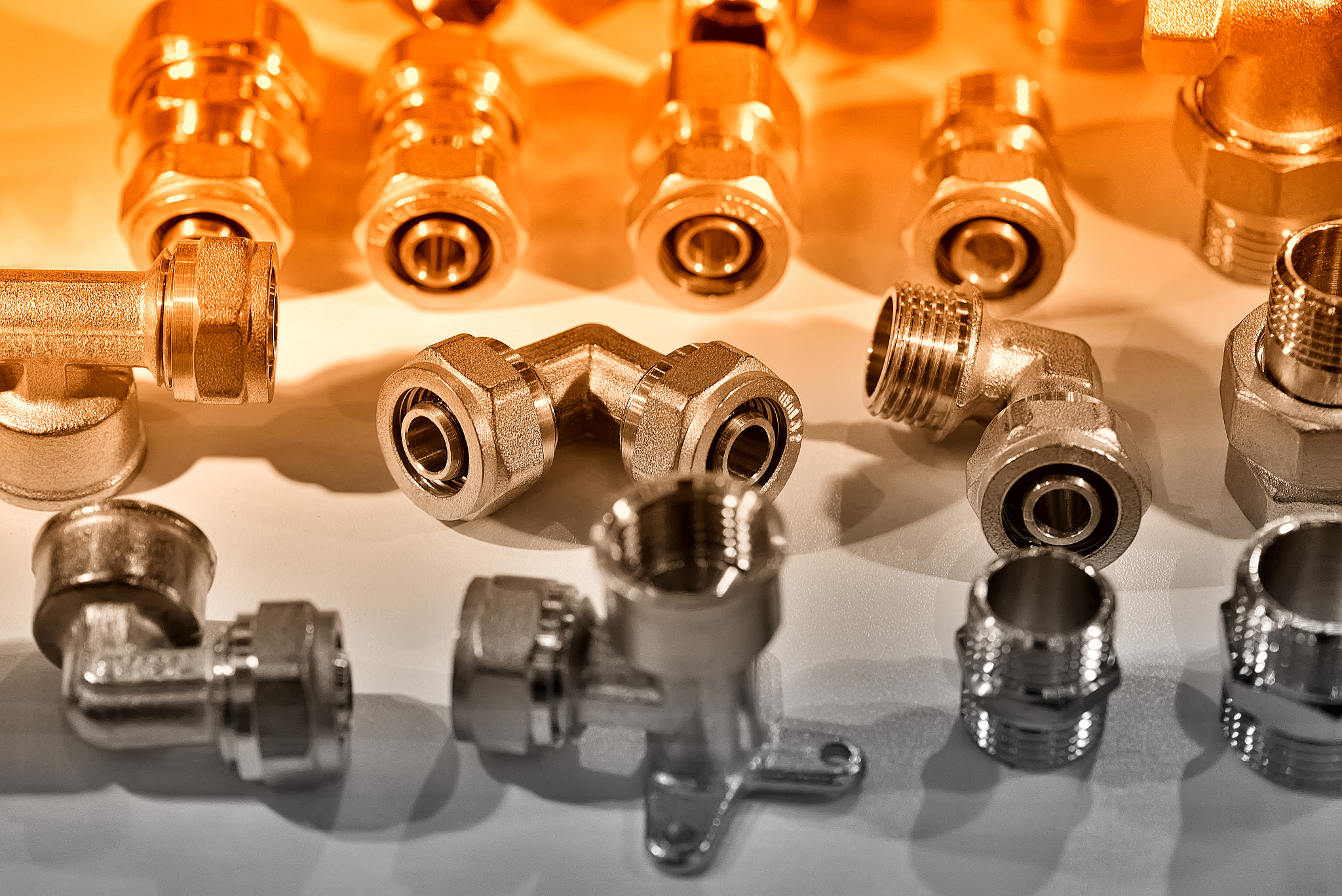 a variety of plumbing pipe connectors, adapters. red toned