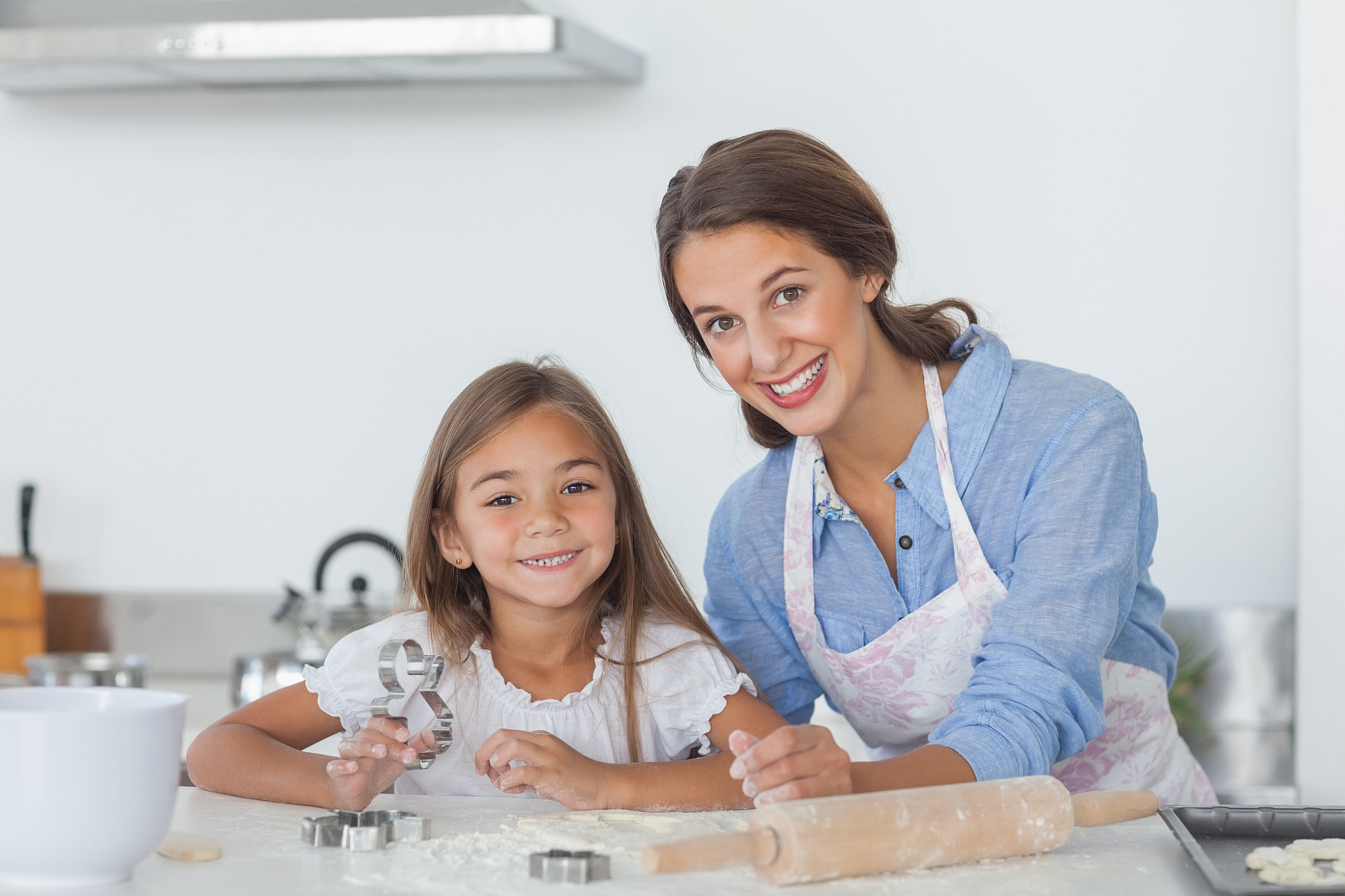 portrait of mother and daughter baking together in the kitchen