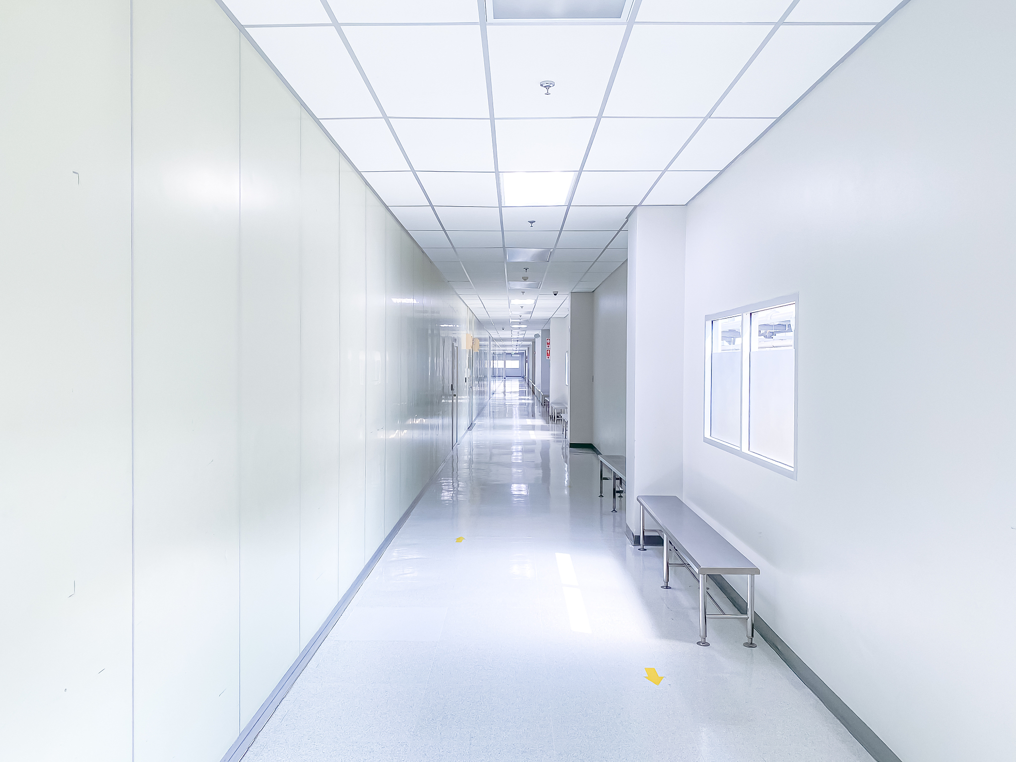 illuminated long white corridor in modern office building