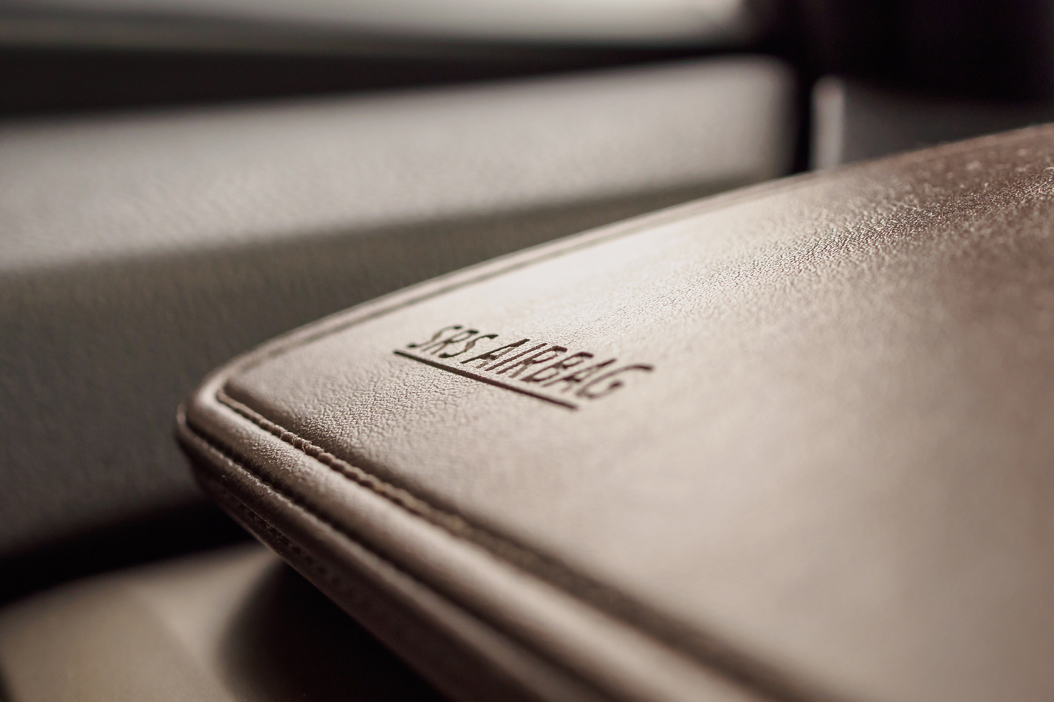 airbag safety sign on brown leather texture in modern car
