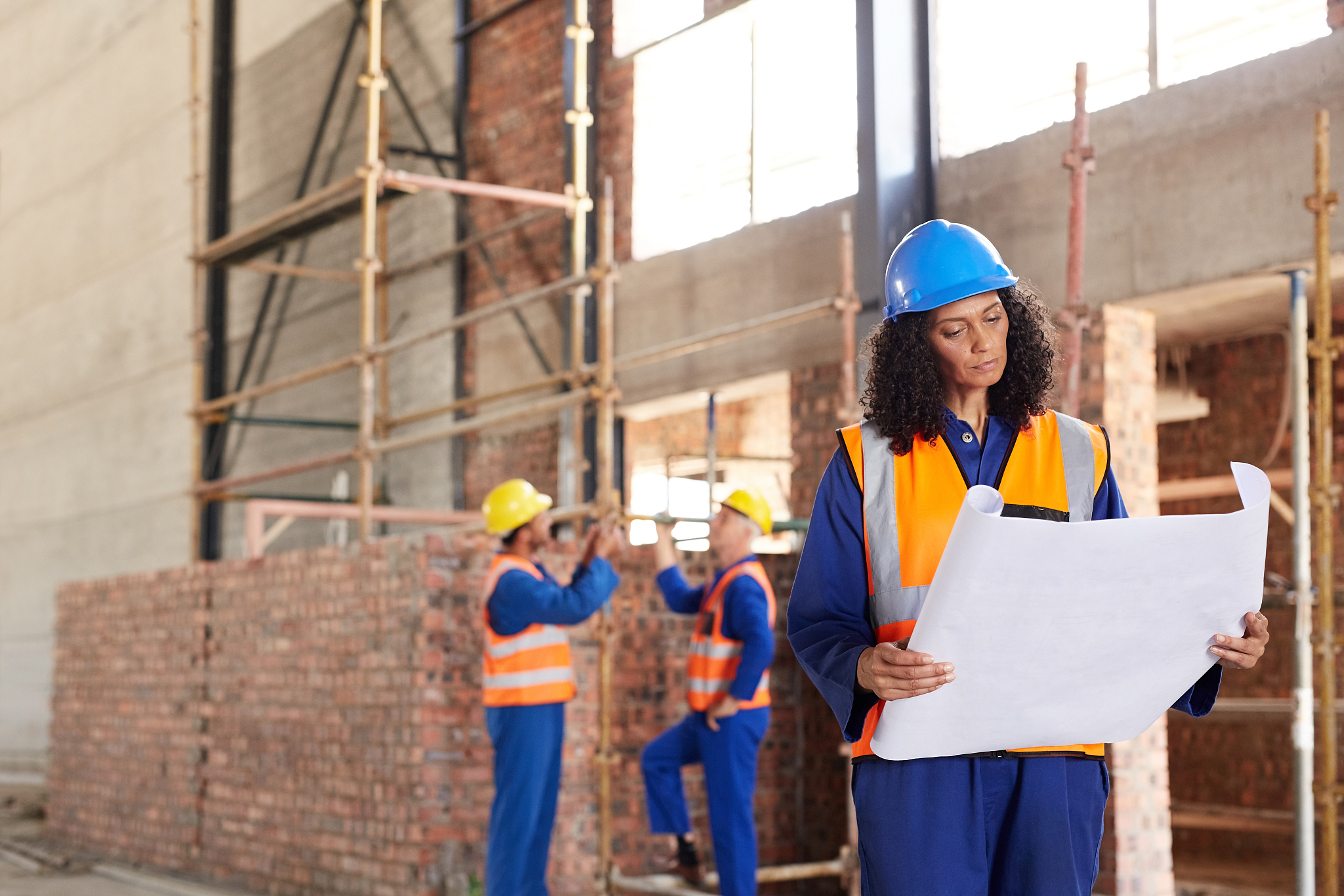 female construction engineer reading blueprints on a worksite