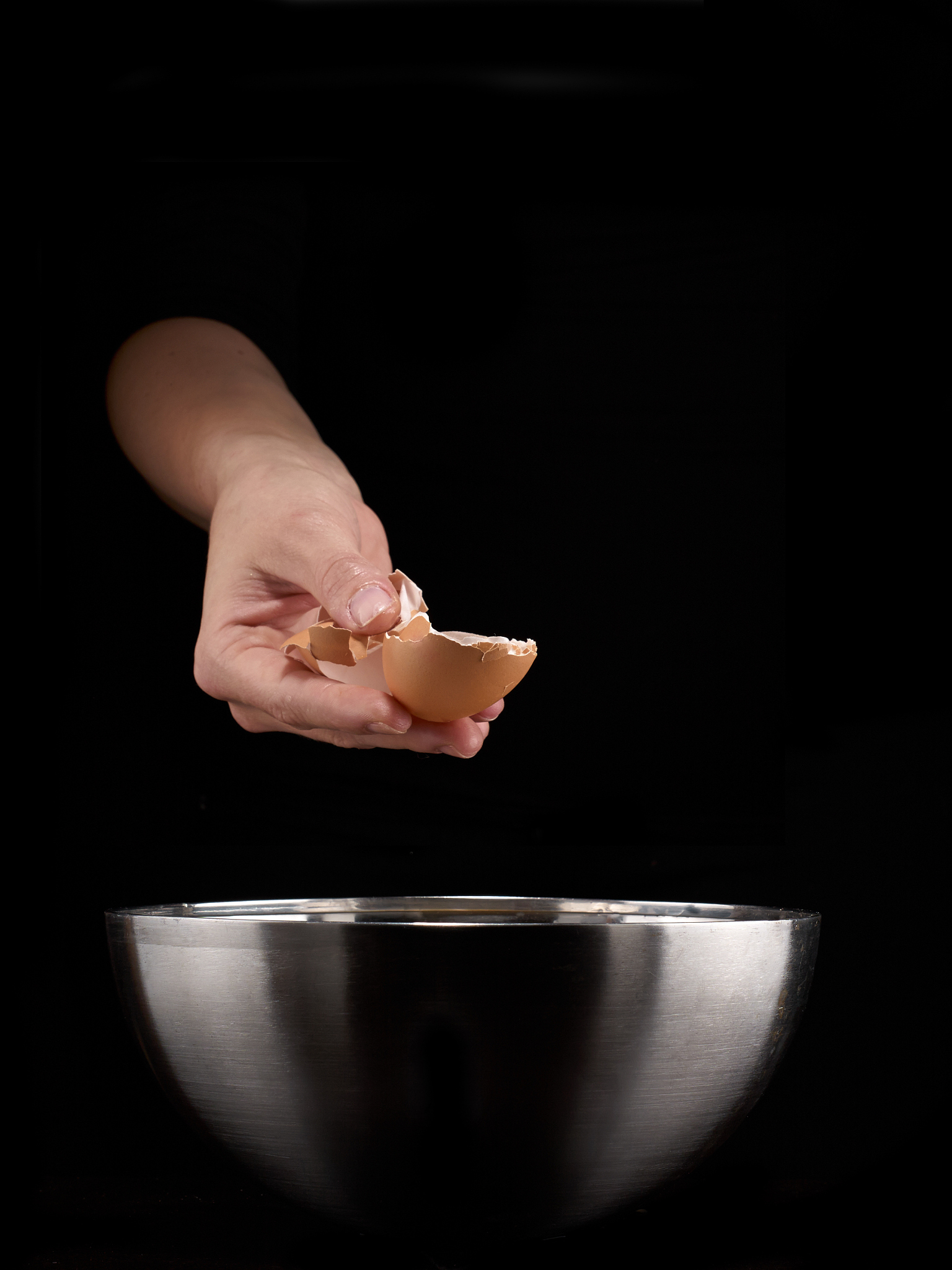 hands breaking an egg
