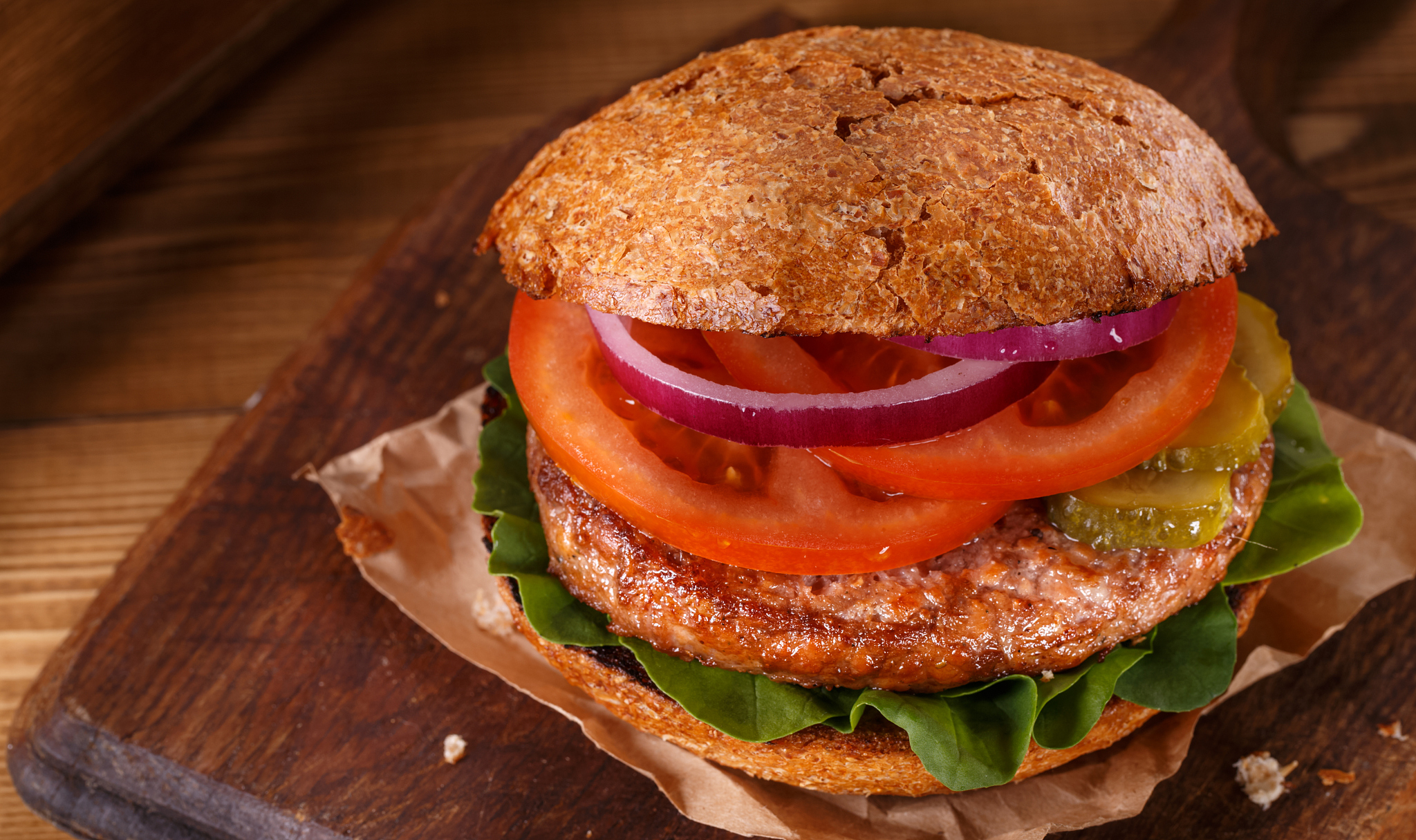 burger close up on a cutting board on wooden background.
